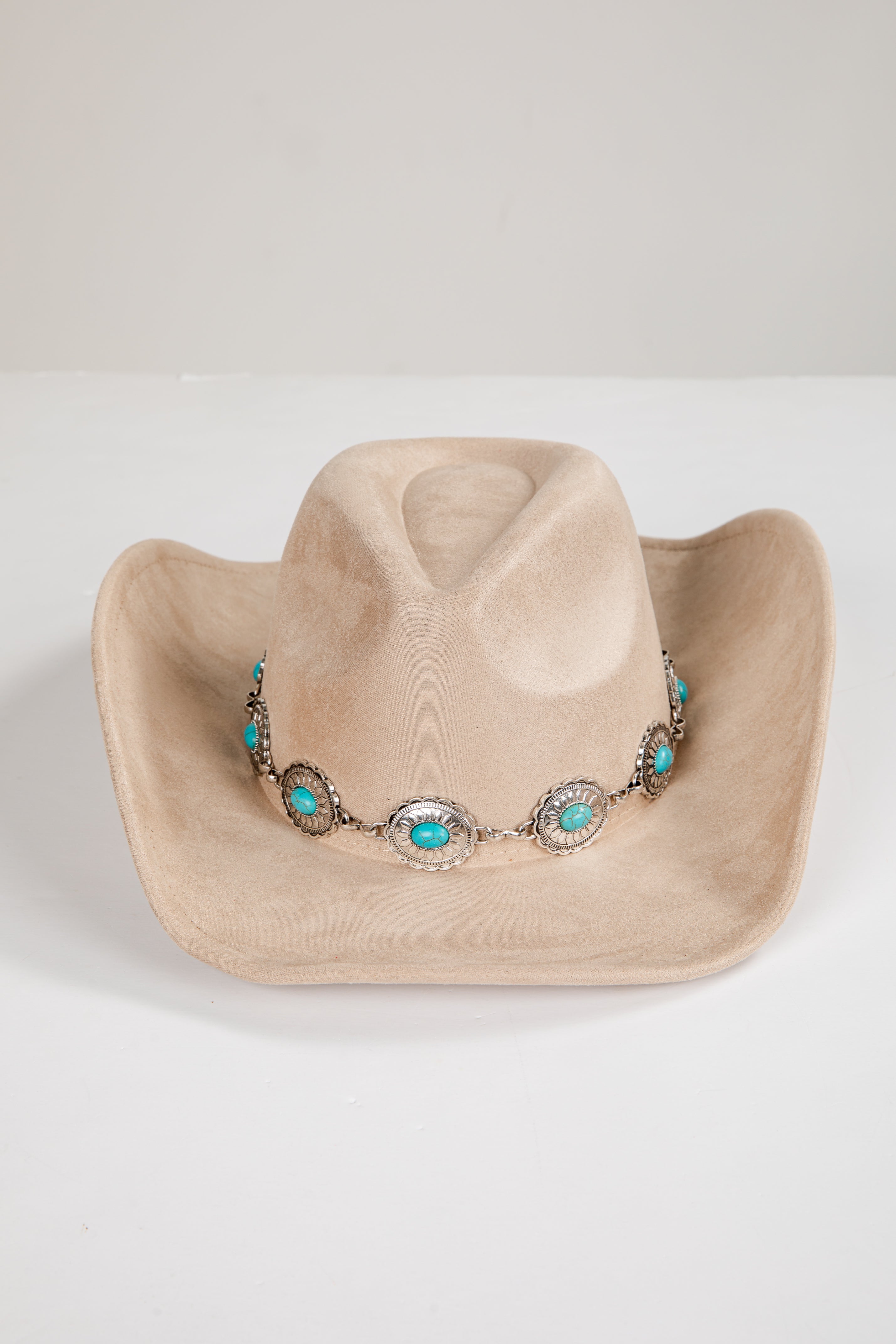 Beige cowboy hat with turquoise and silver decorative band on a white background