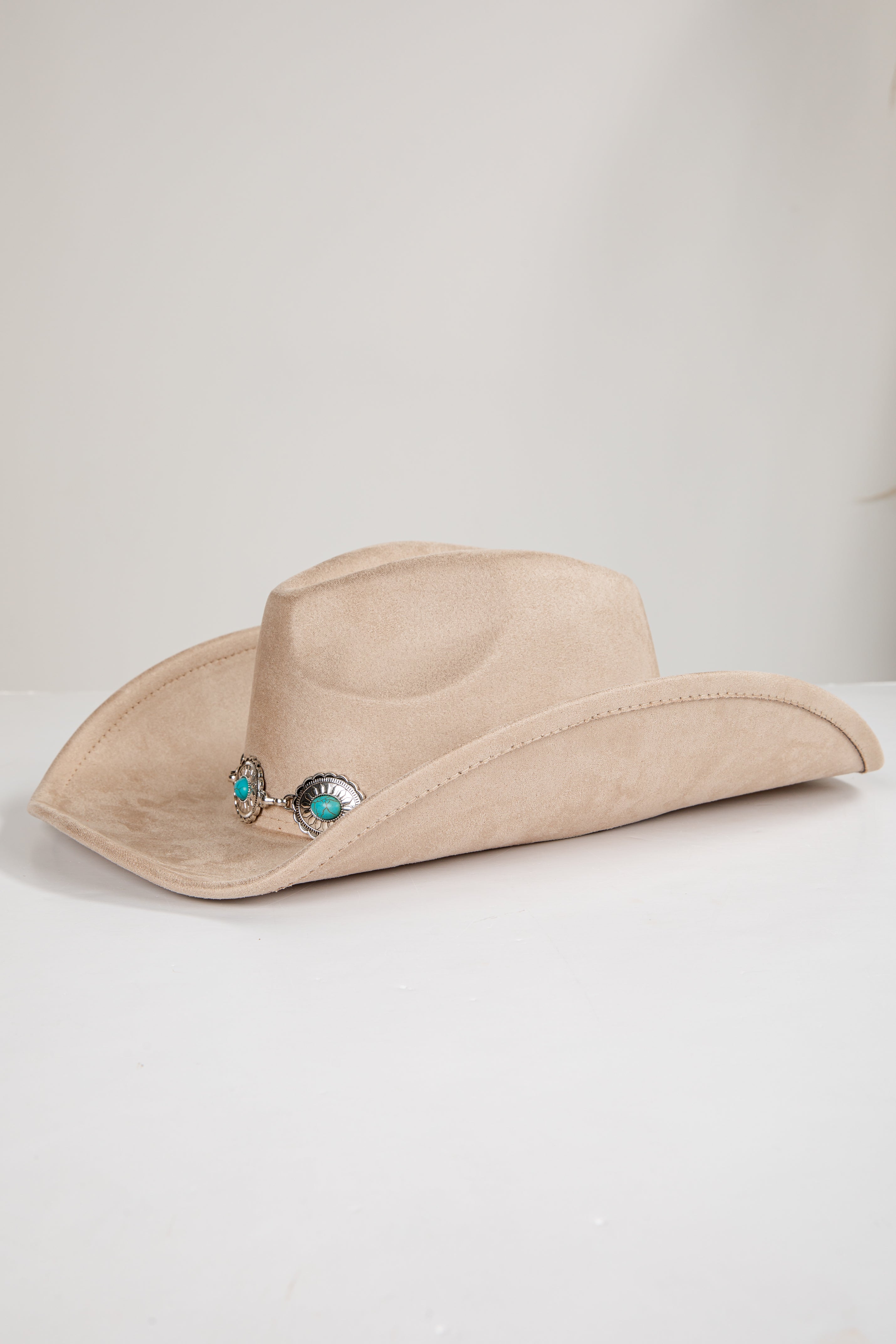 Beige cowboy hat with decorative elements on a white background