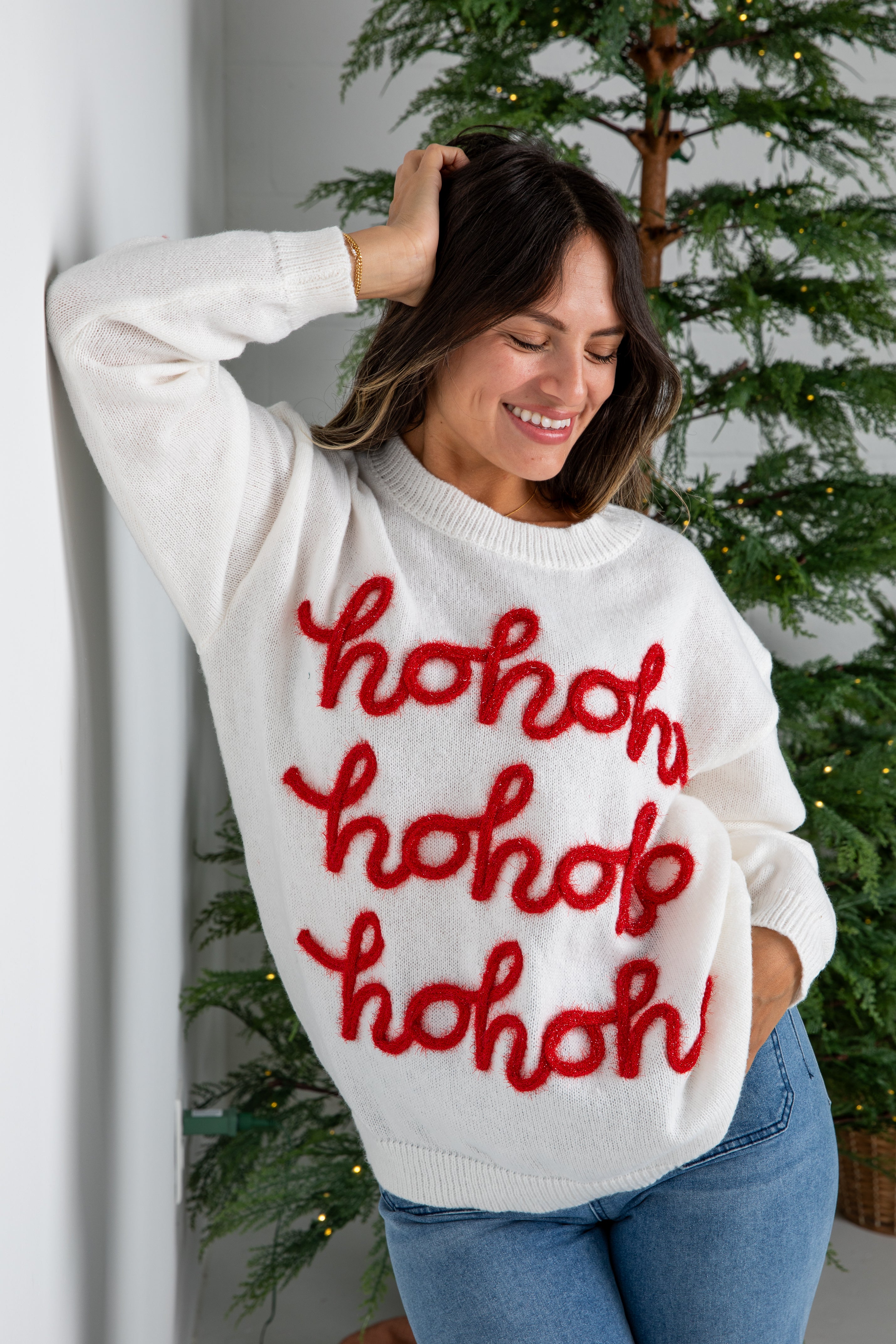 Woman wearing a white sweater with red &