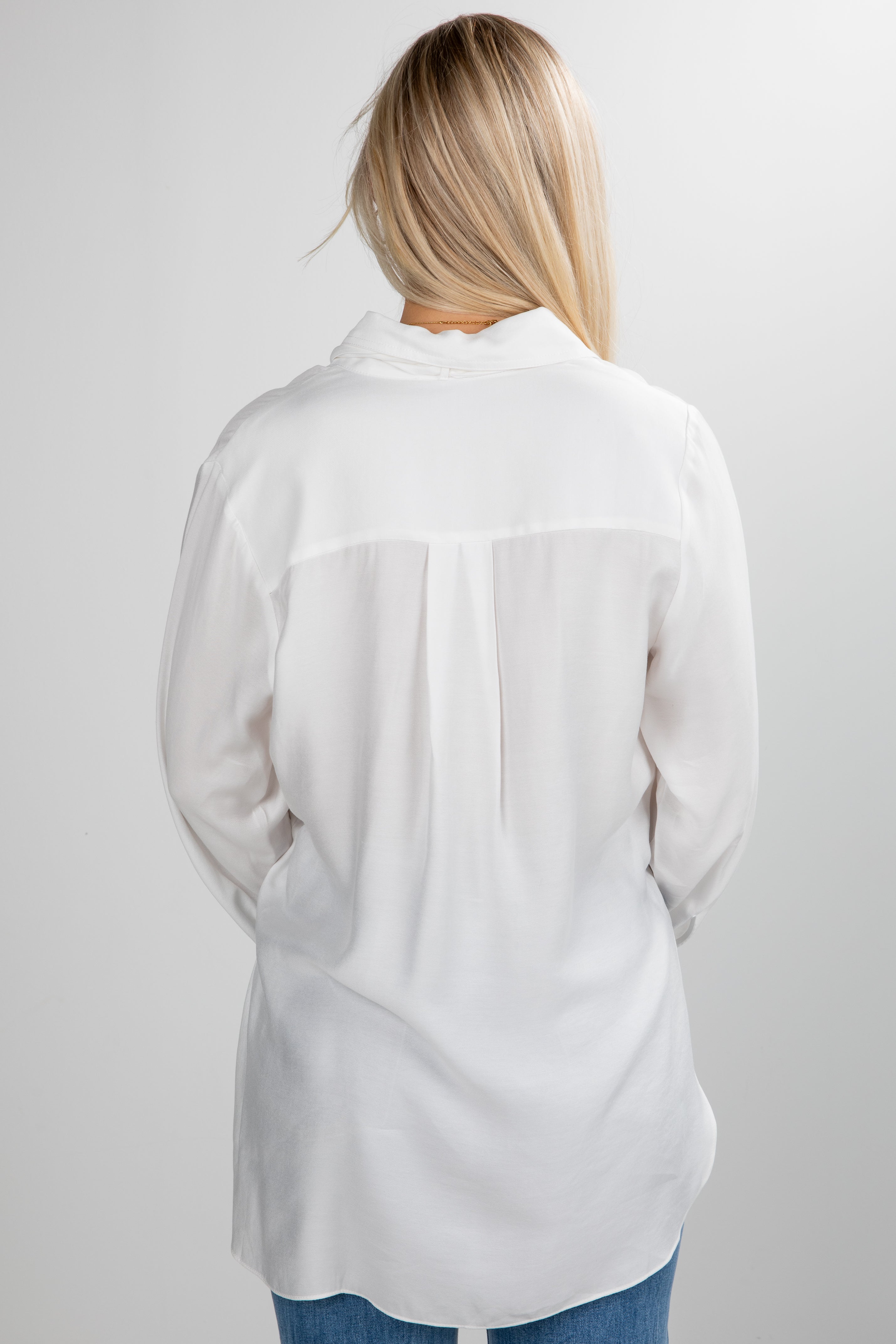 Person wearing a white shirt on a plain background