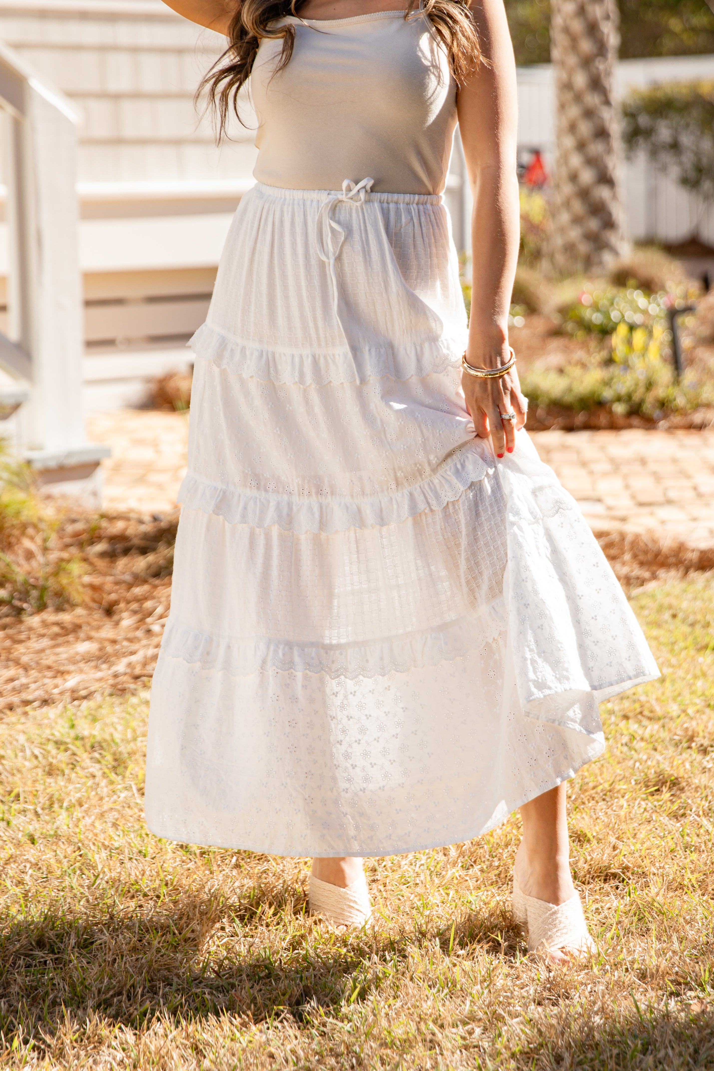 Woman wearing a white dress standing outdoors on grass