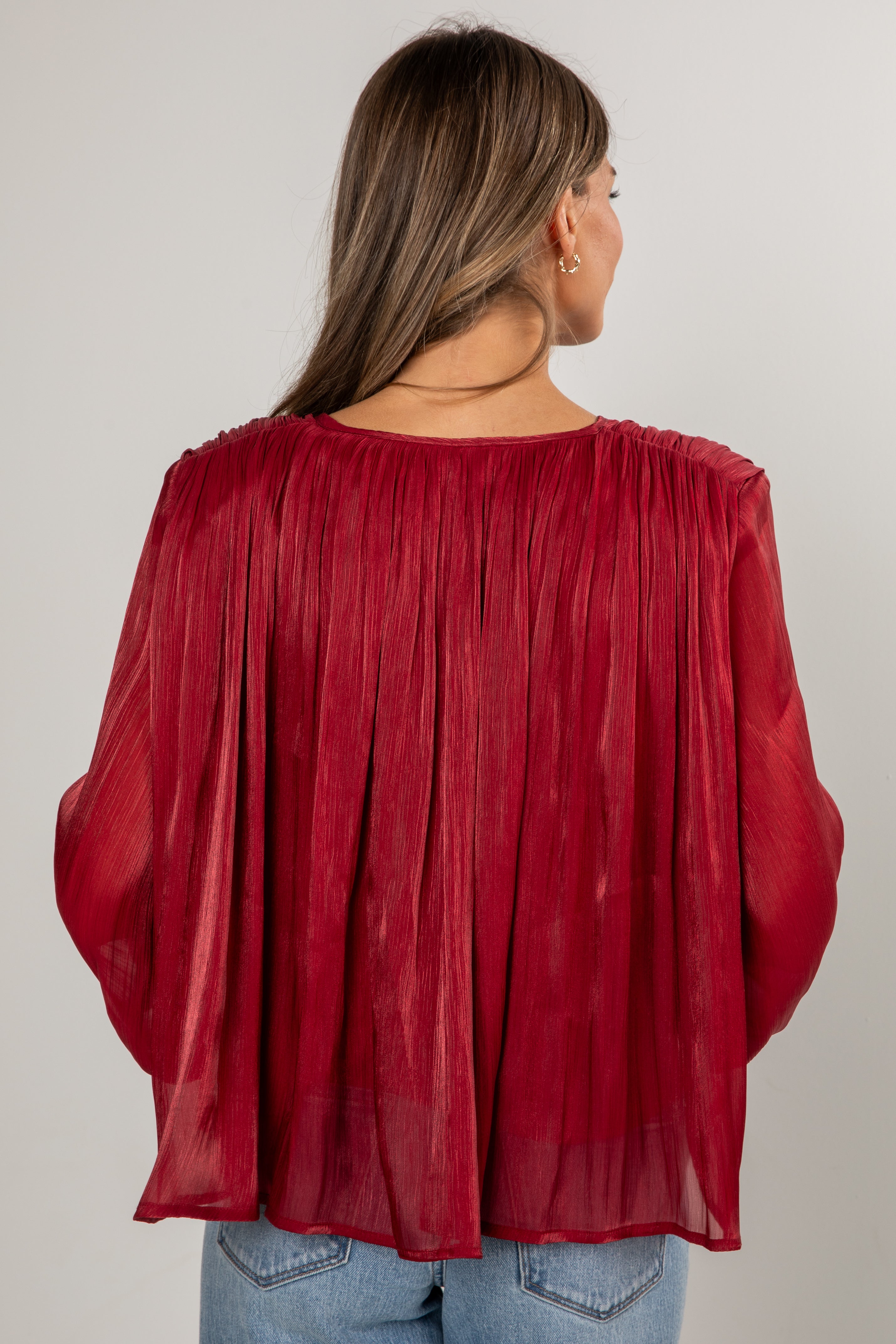Red sheer blouse worn by a person on a plain background