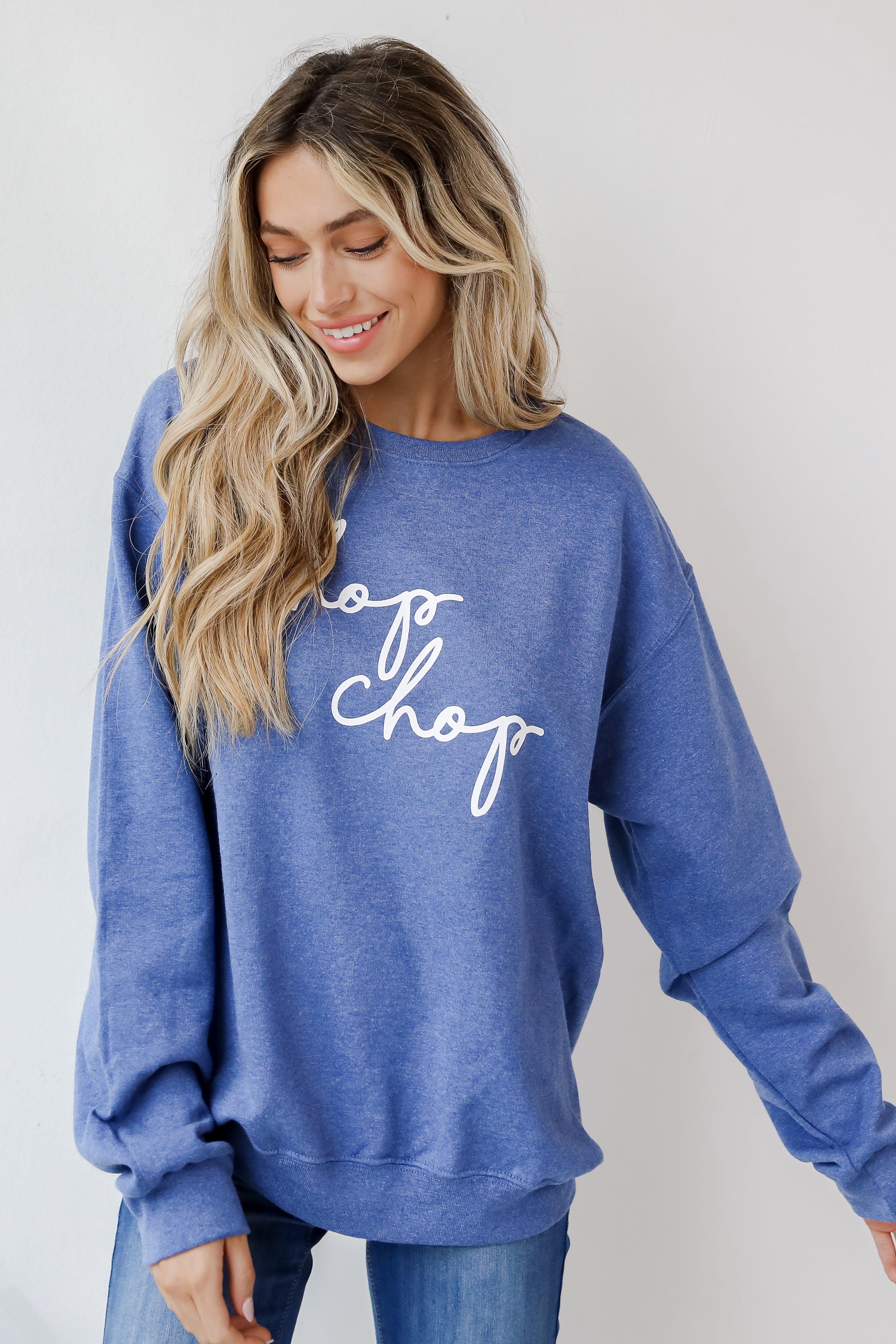 This comfy sweatshirt is designed with a soft and stretchy knit with a fleece interior. It features a crew neckline, long sleeves, a relaxed fit, and the words "Chop Chop" on the front.