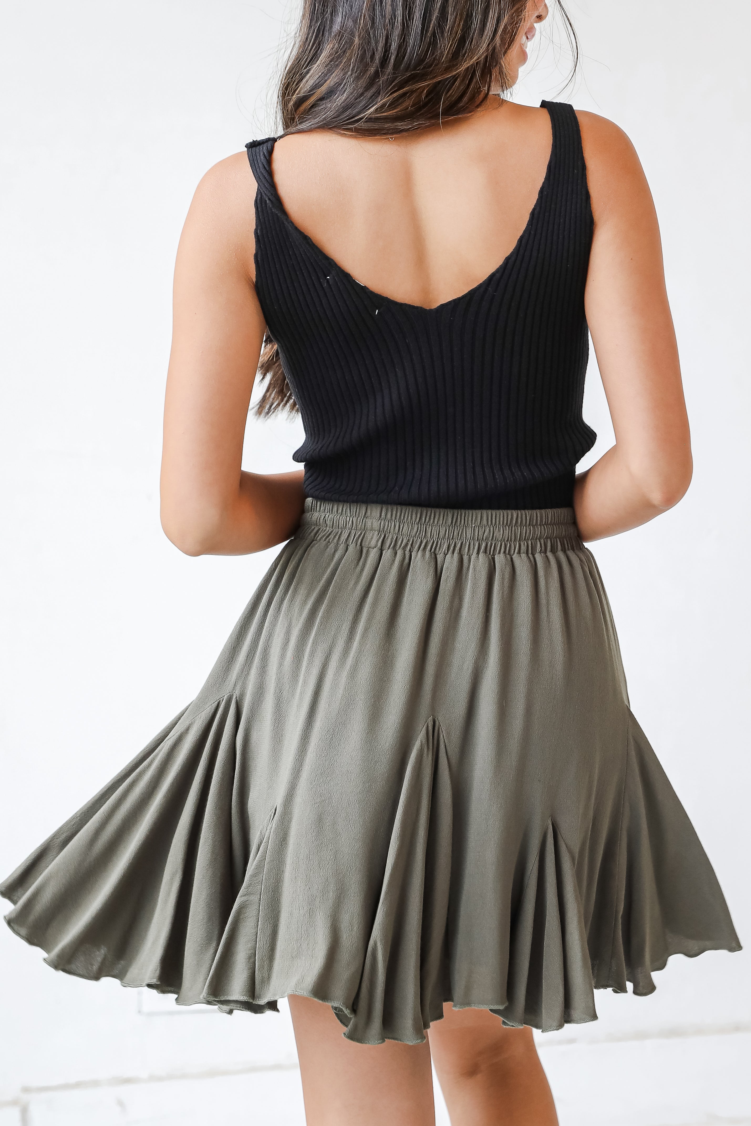This cute skirt is designed with a lightweight woven knit. It features an elastic waistband with a functional drawstring and a flowy fit that ends at a mini length.