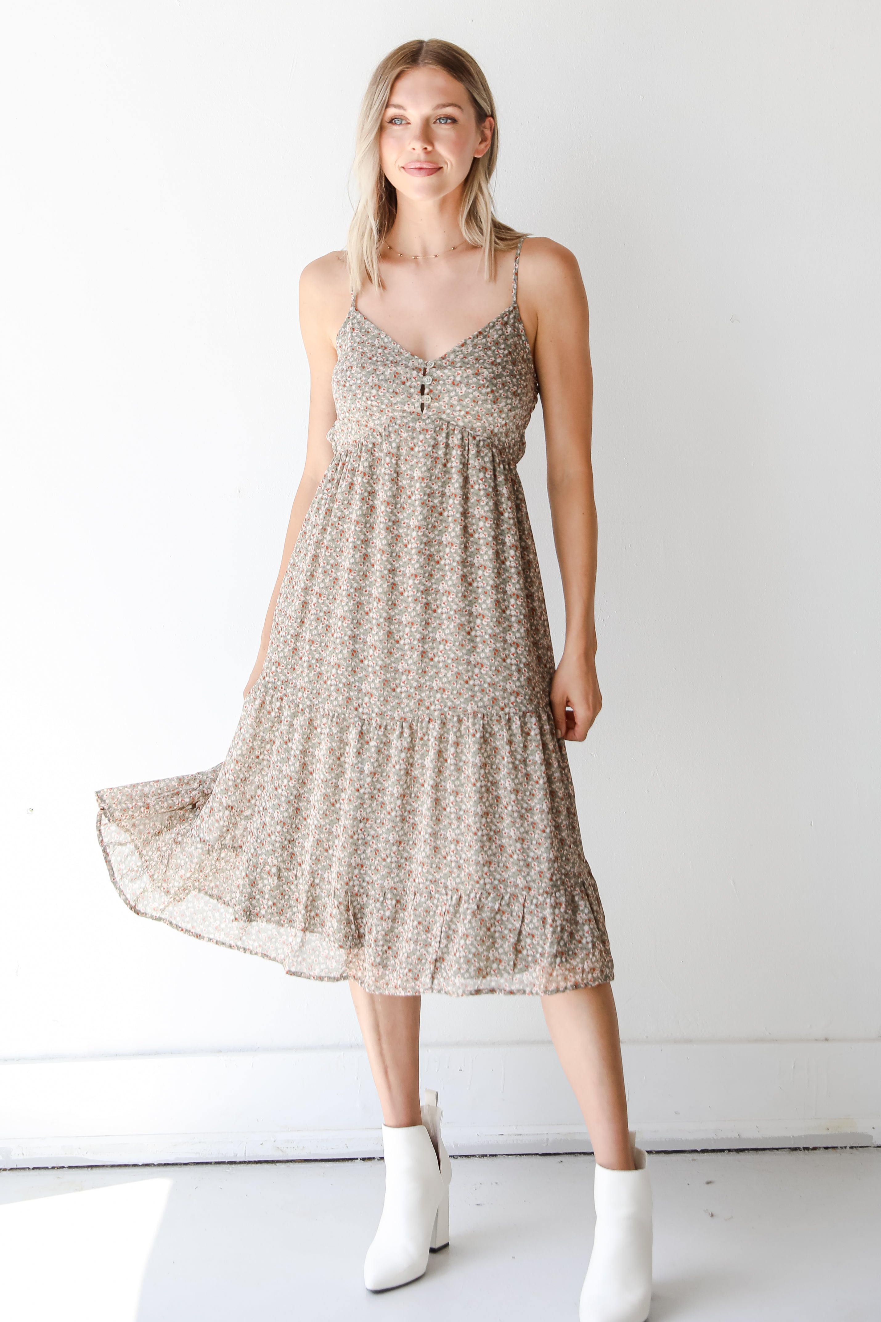 model wearing a floral midi dress with white booties