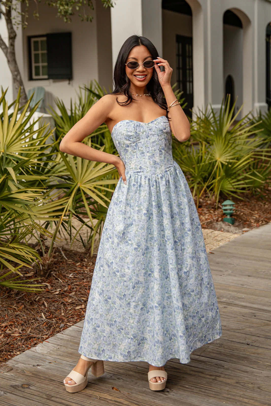 Women wearing a cute maxi dress with sunglasses and wedges outside.