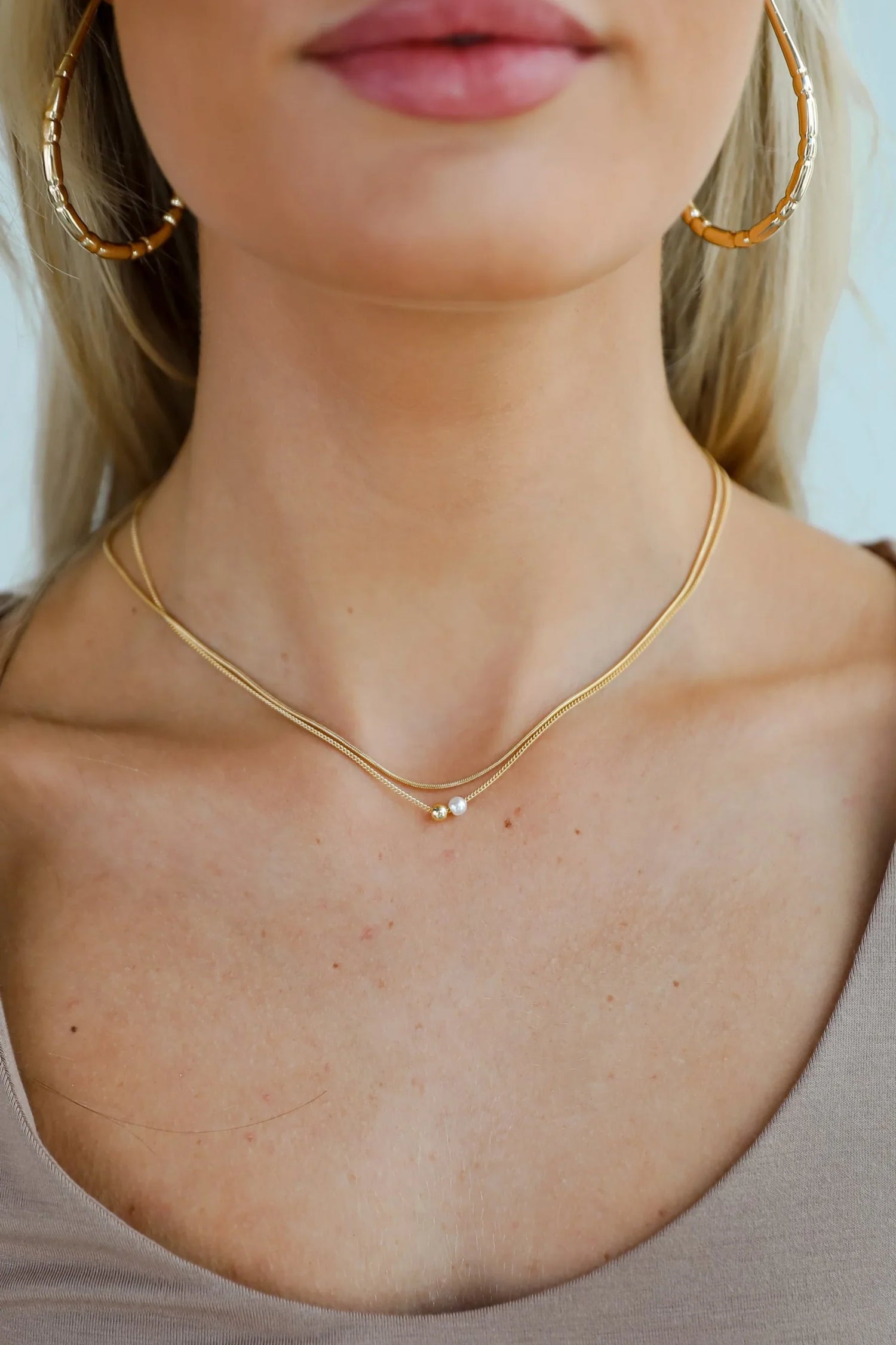 woman wearing a gold necklace 