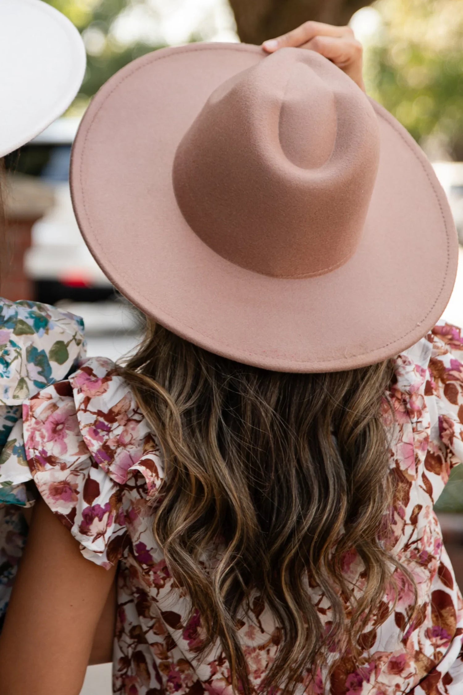 Woman outside wearing a wide brim hat tan. Hats