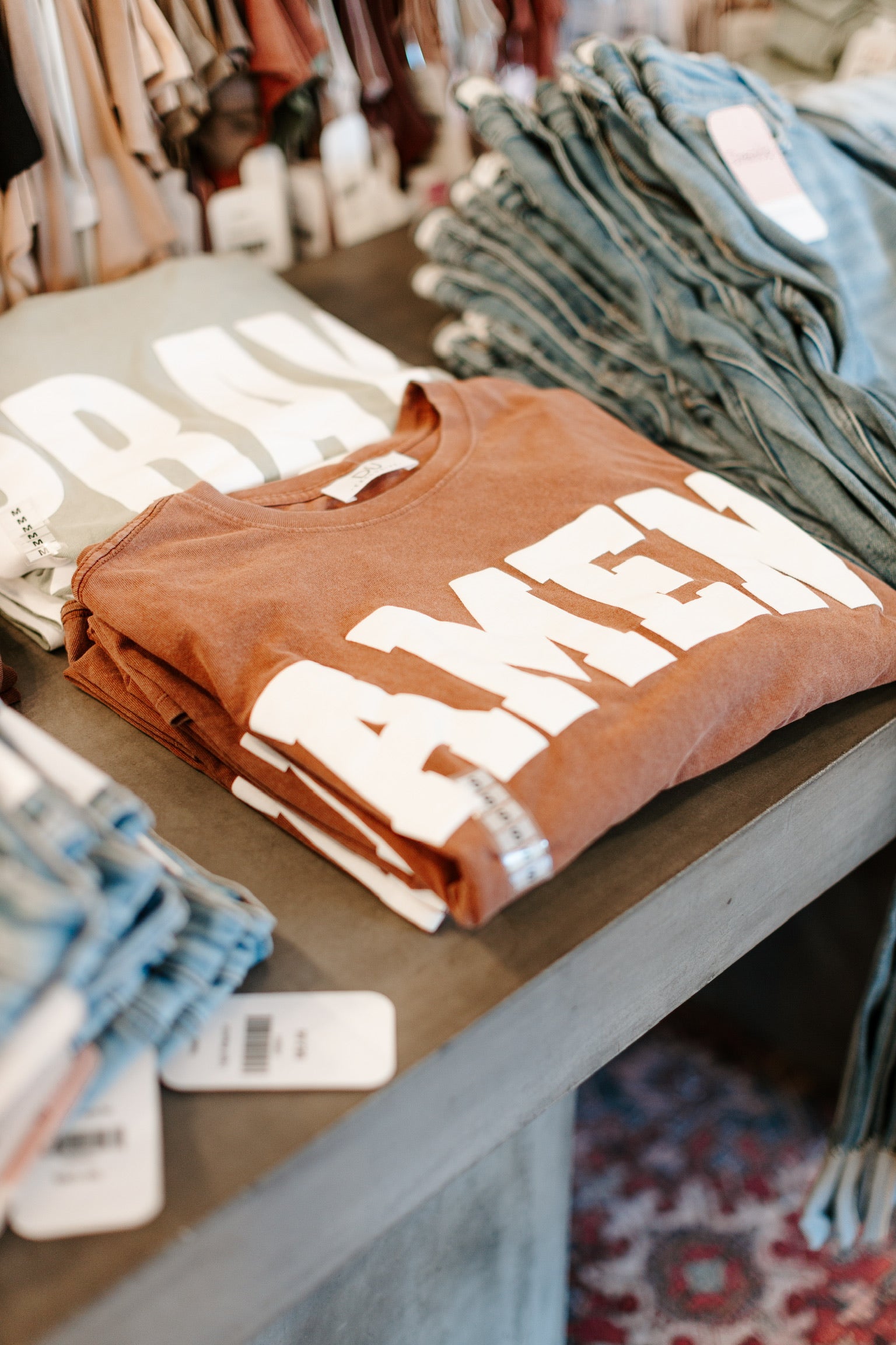 front table with amen oversized tee folded with jeans to pair