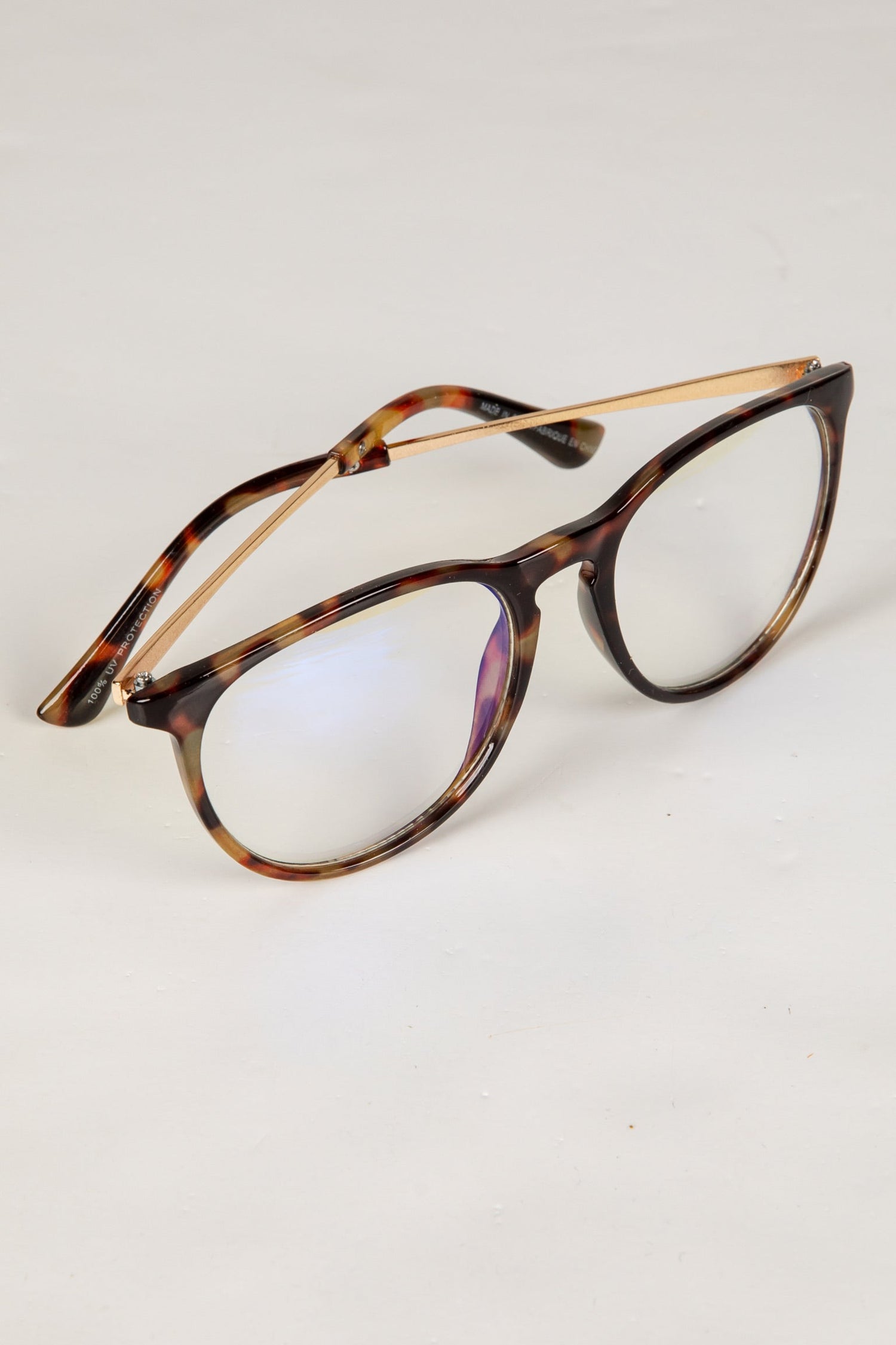 Tortoiseshell eyeglasses on a light gray background