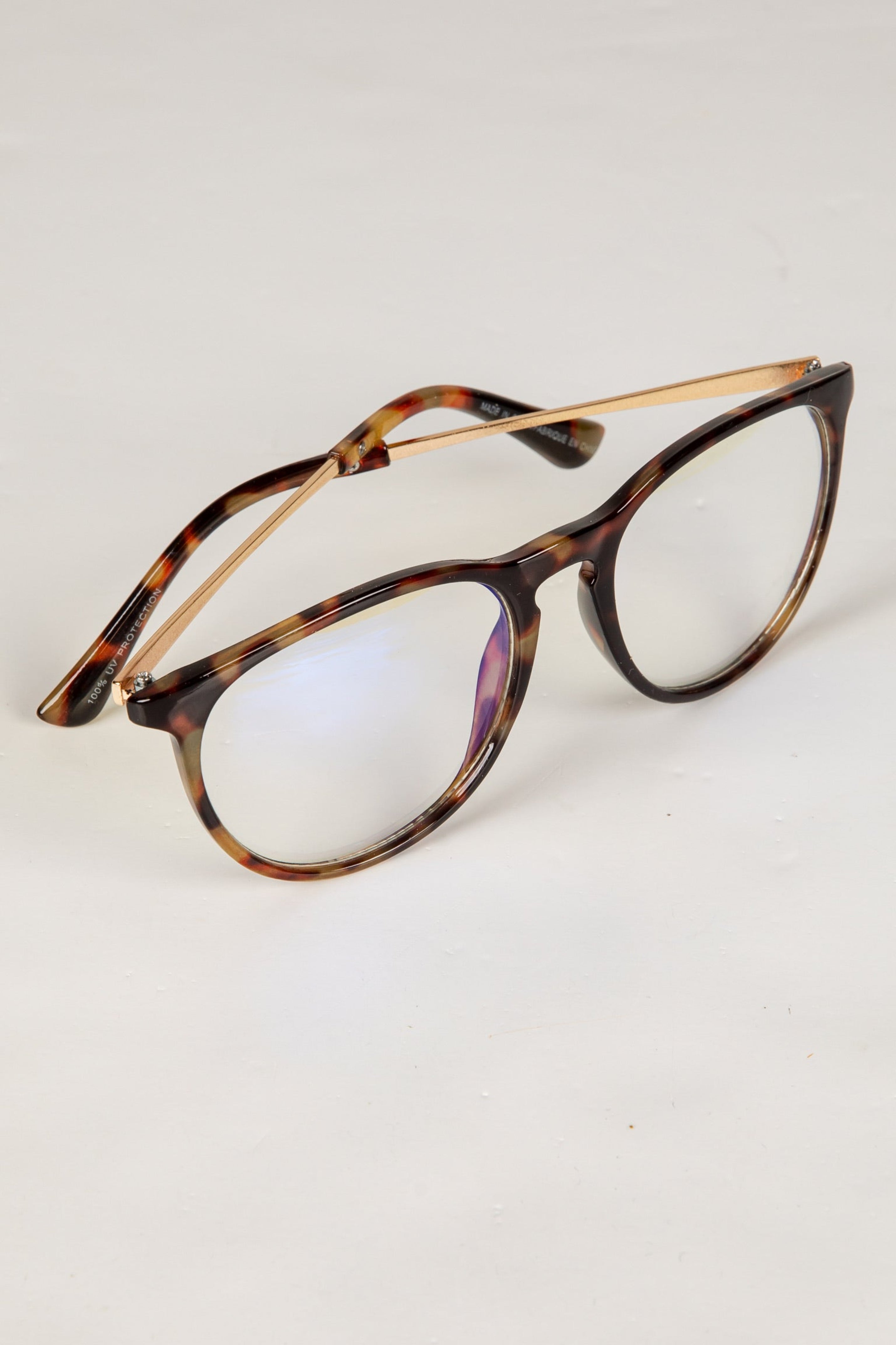 Tortoiseshell eyeglasses on a light gray background