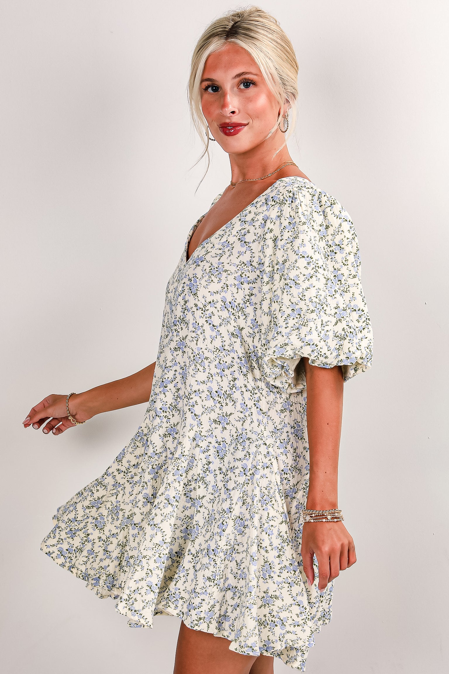 Woman wearing a floral dress against a plain background