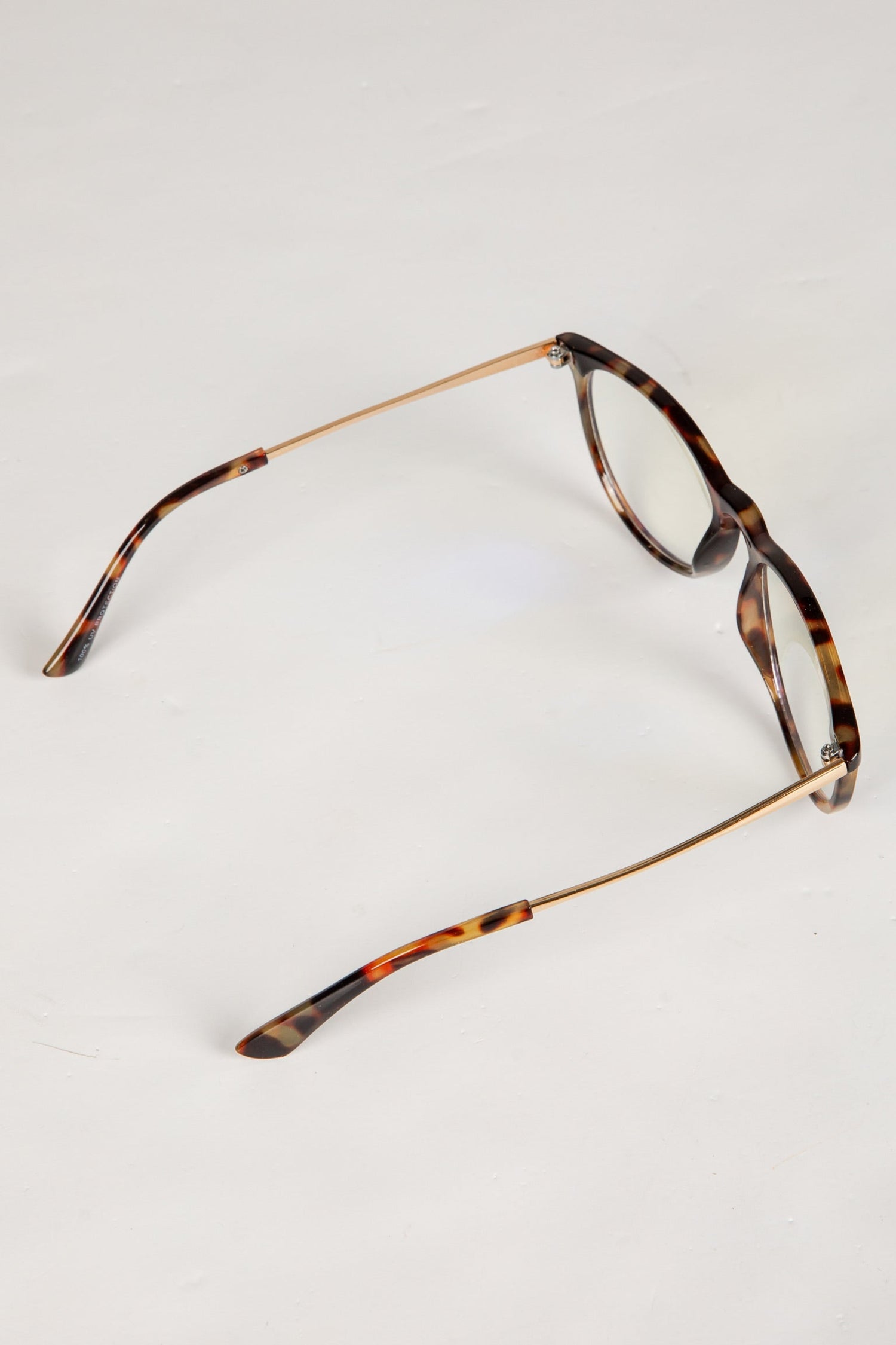 Tortoiseshell eyeglasses on a light gray background