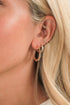 Close-up of a person wearing rose gold hoop earrings with blonde hair.