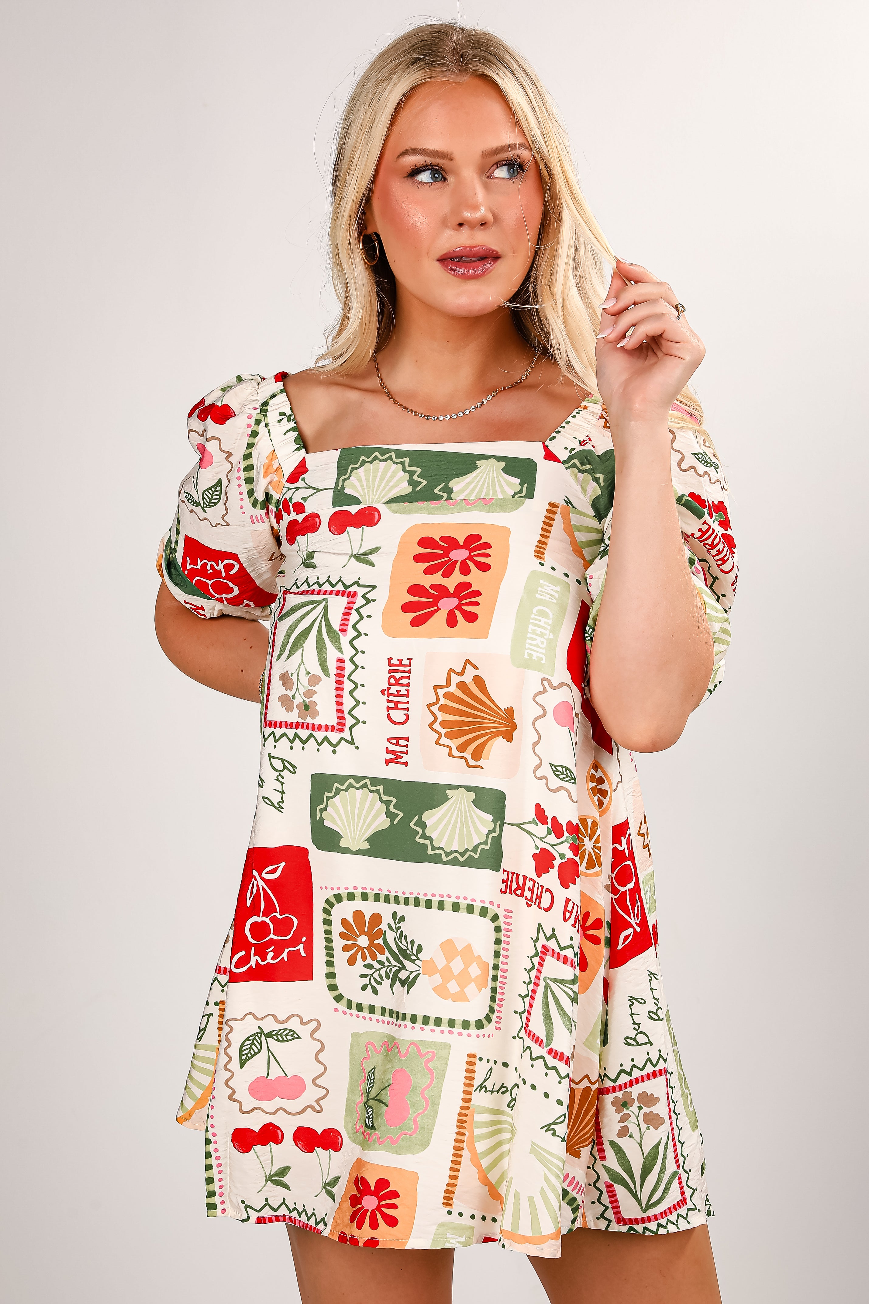 Woman wearing a colorful patterned dress on a plain background