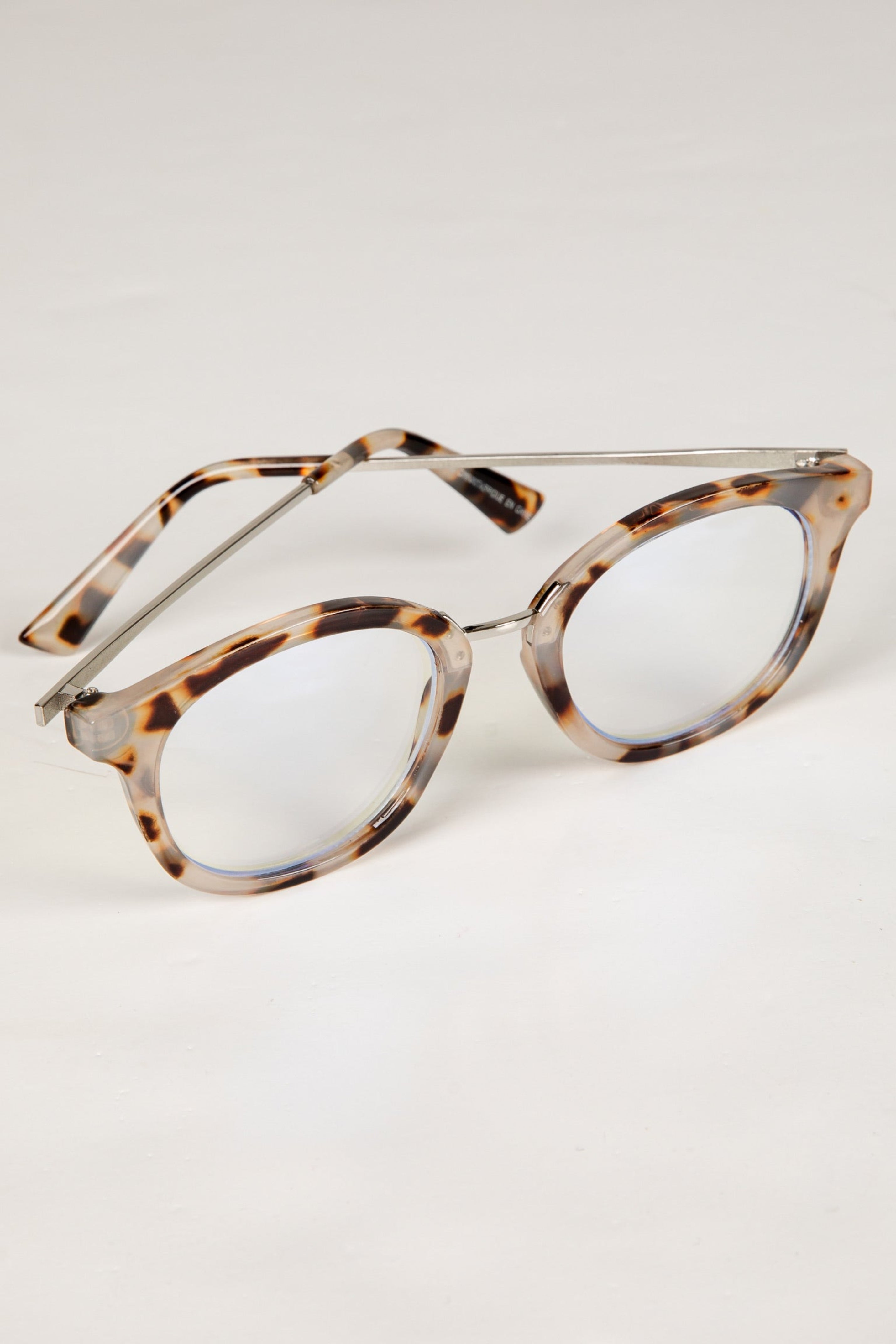 Tortoiseshell eyeglasses on a light gray background