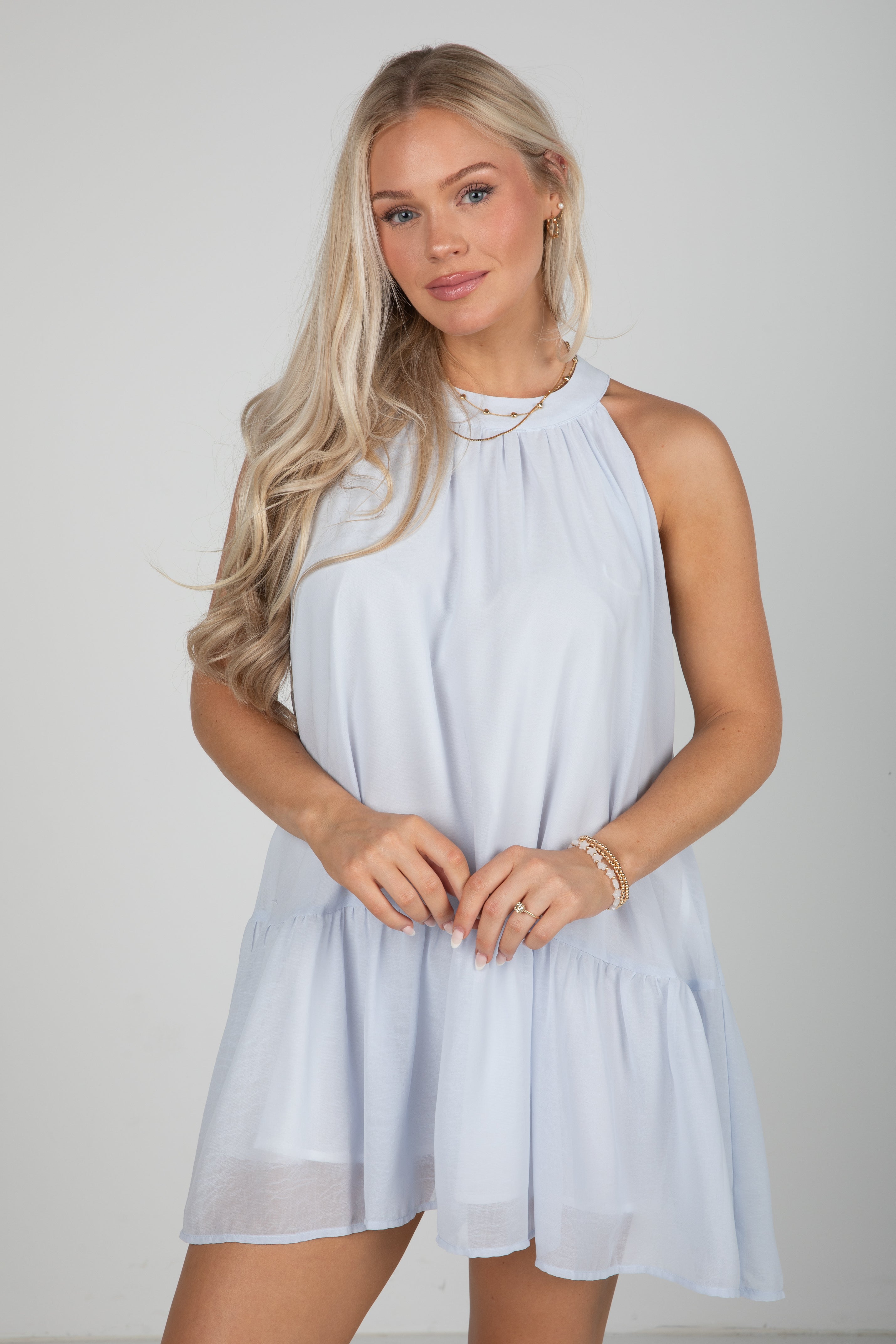 Woman wearing a light blue dress against a plain background
