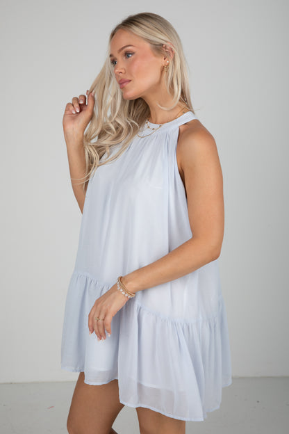 Woman wearing a light blue dress against a plain background