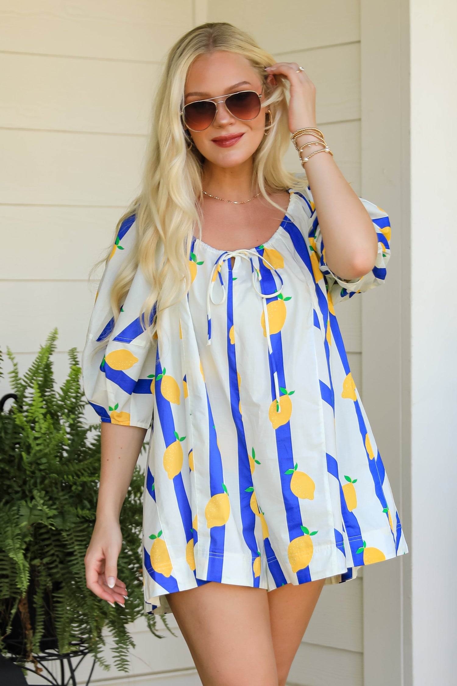 Woman wearing a colorful dress with a lemon pattern outdoors.