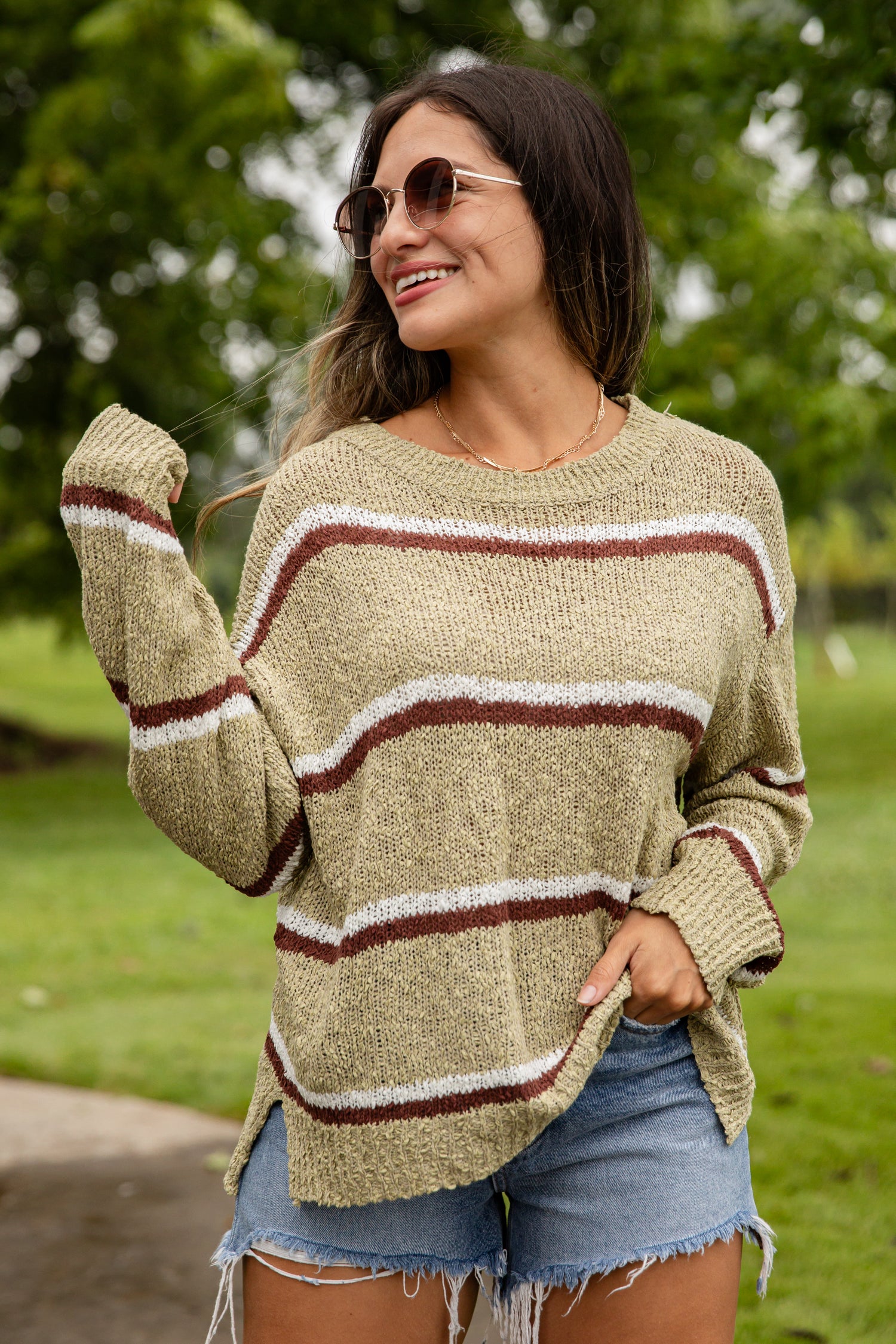Woman wearing a striped sweater and sunglasses outdoors
