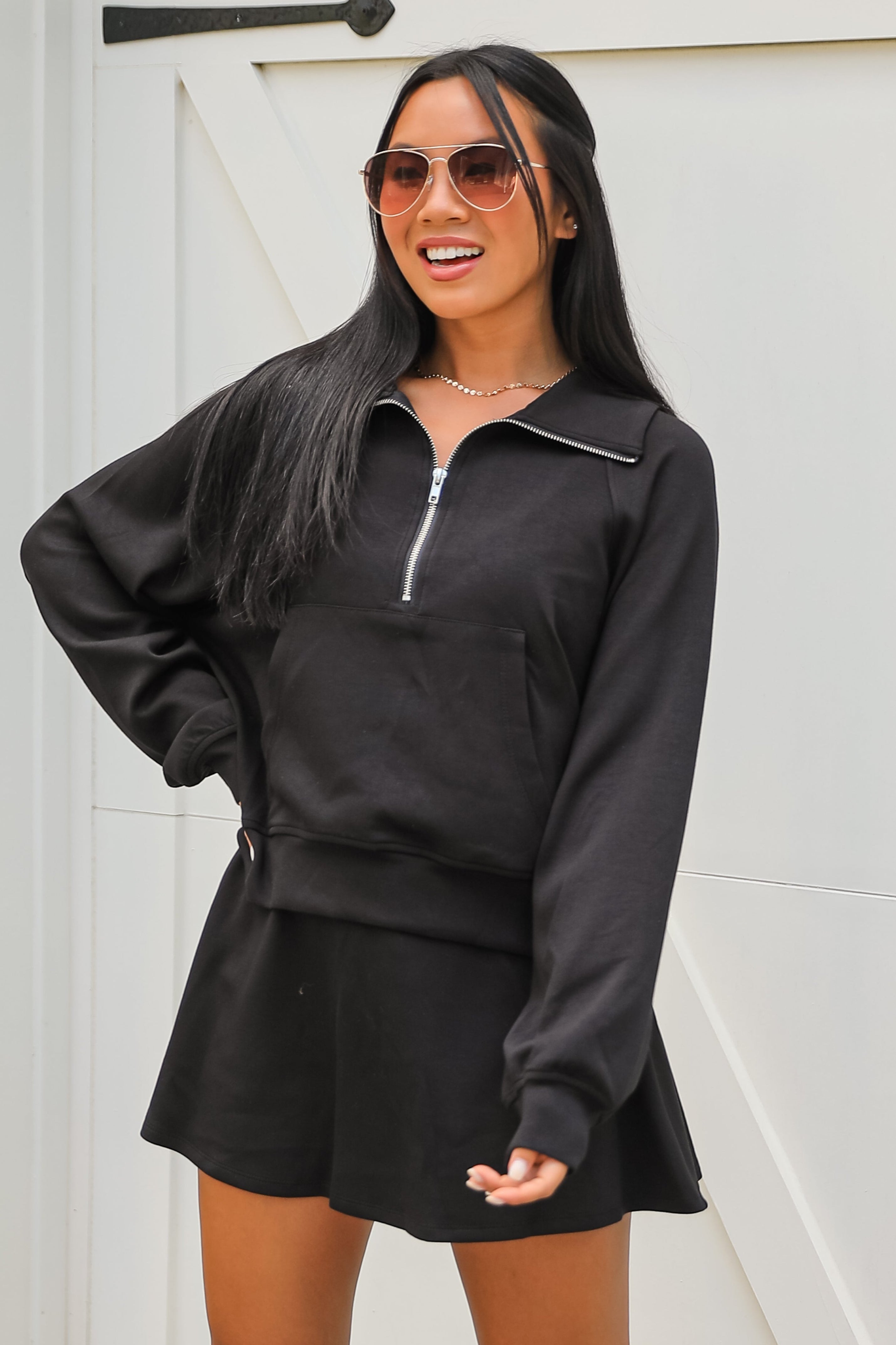 Woman wearing a black outfit with a white door in the background