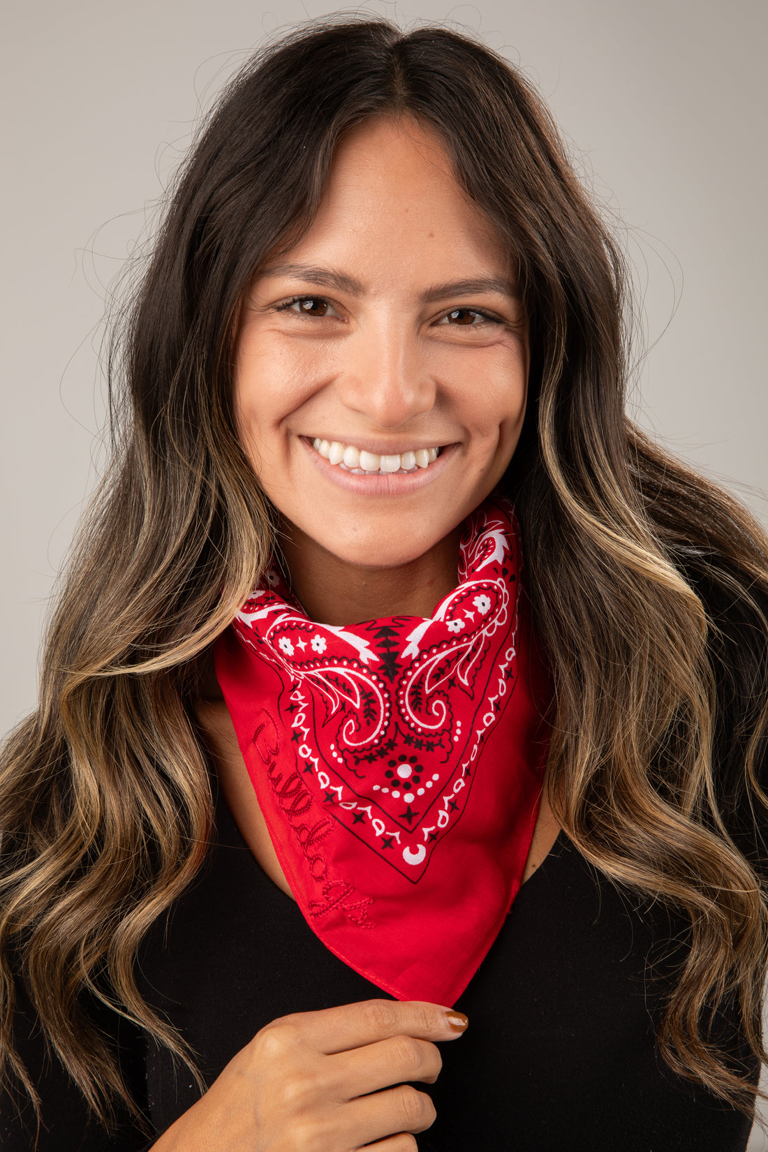 Woman wearing a red bandana with a pattern against a neutral background