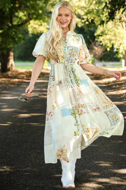 Woman in a floral dress standing outdoors with trees in the background