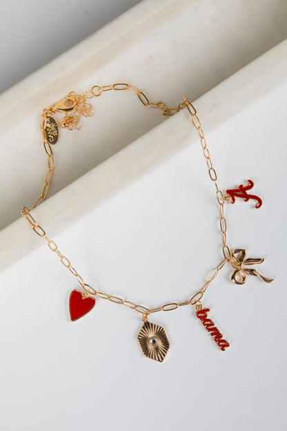 Gold bracelet with various charms including a heart, shell, and &