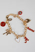 Gold bracelet with various charms including a red &