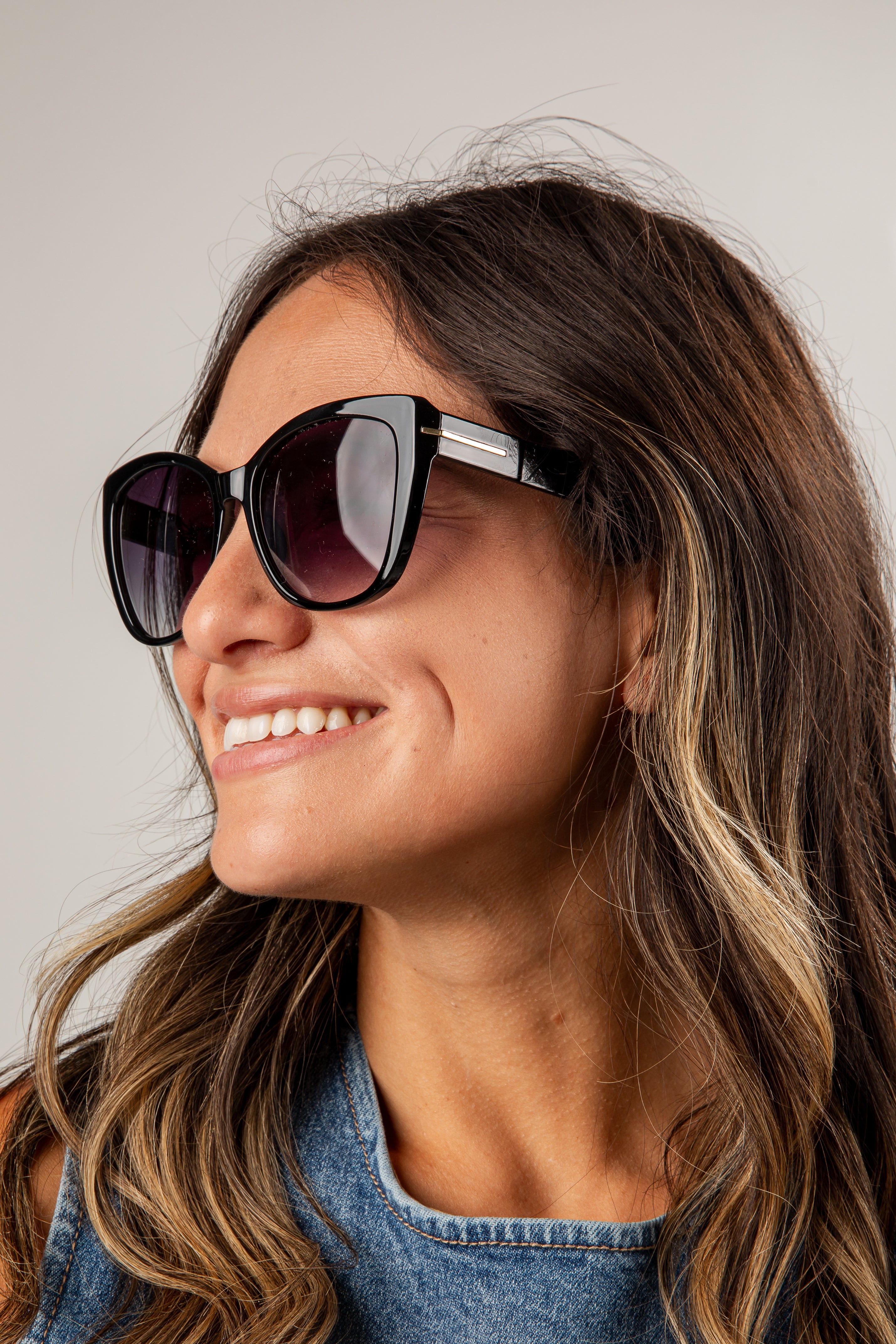 Woman wearing sunglasses with a neutral background