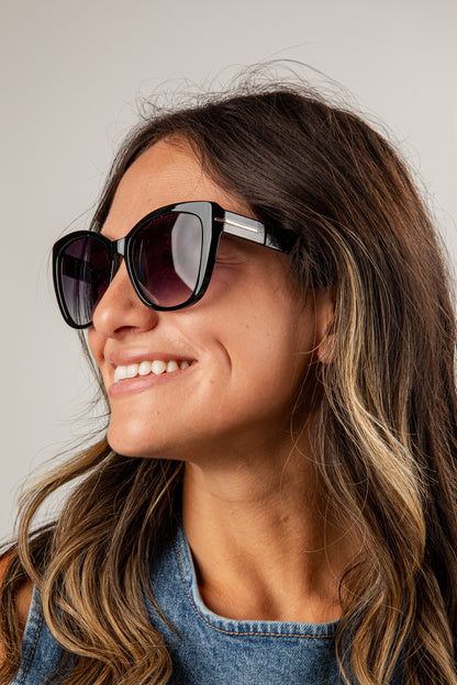 Woman wearing sunglasses with a neutral background