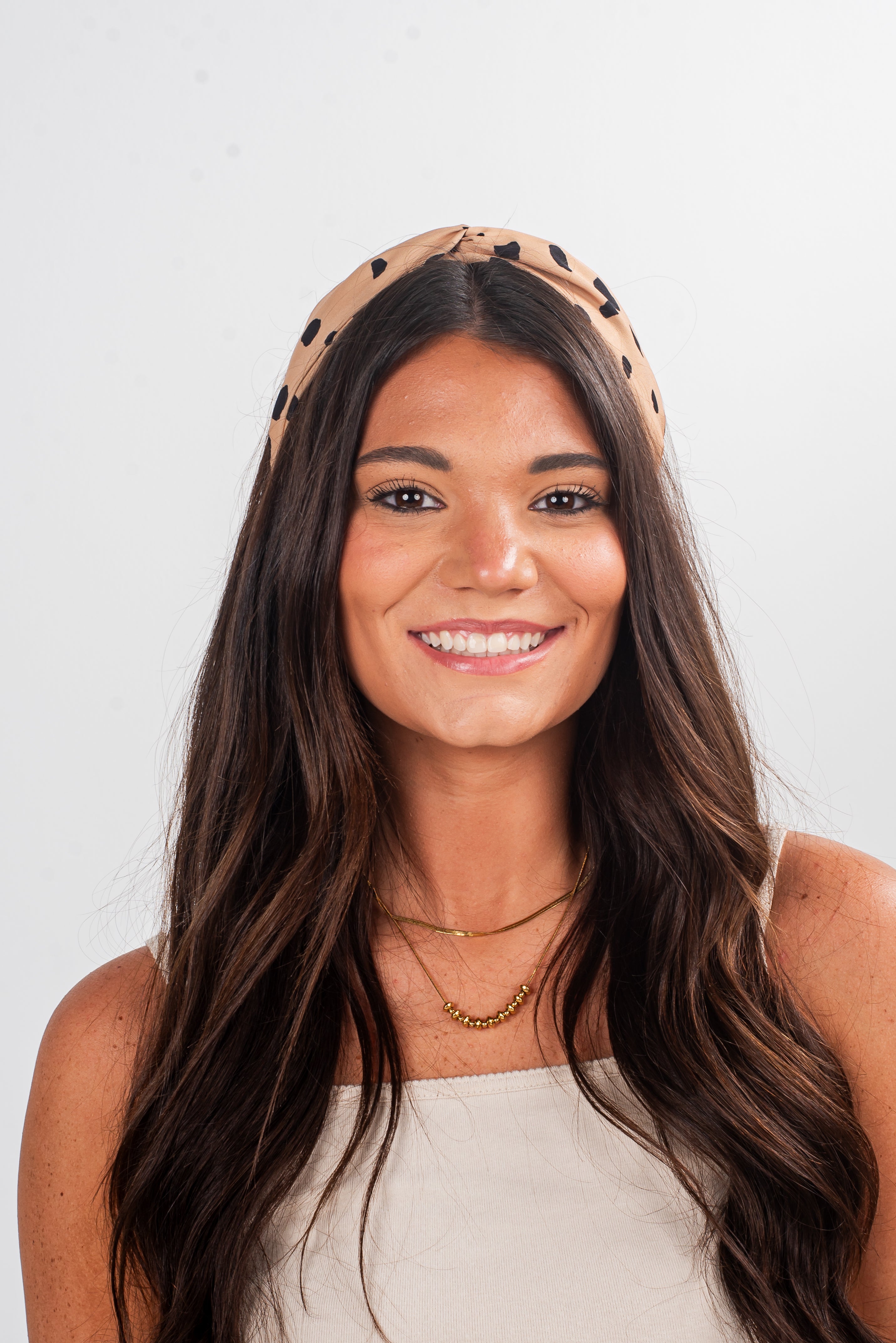 Woman wearing a patterned headband against a plain background