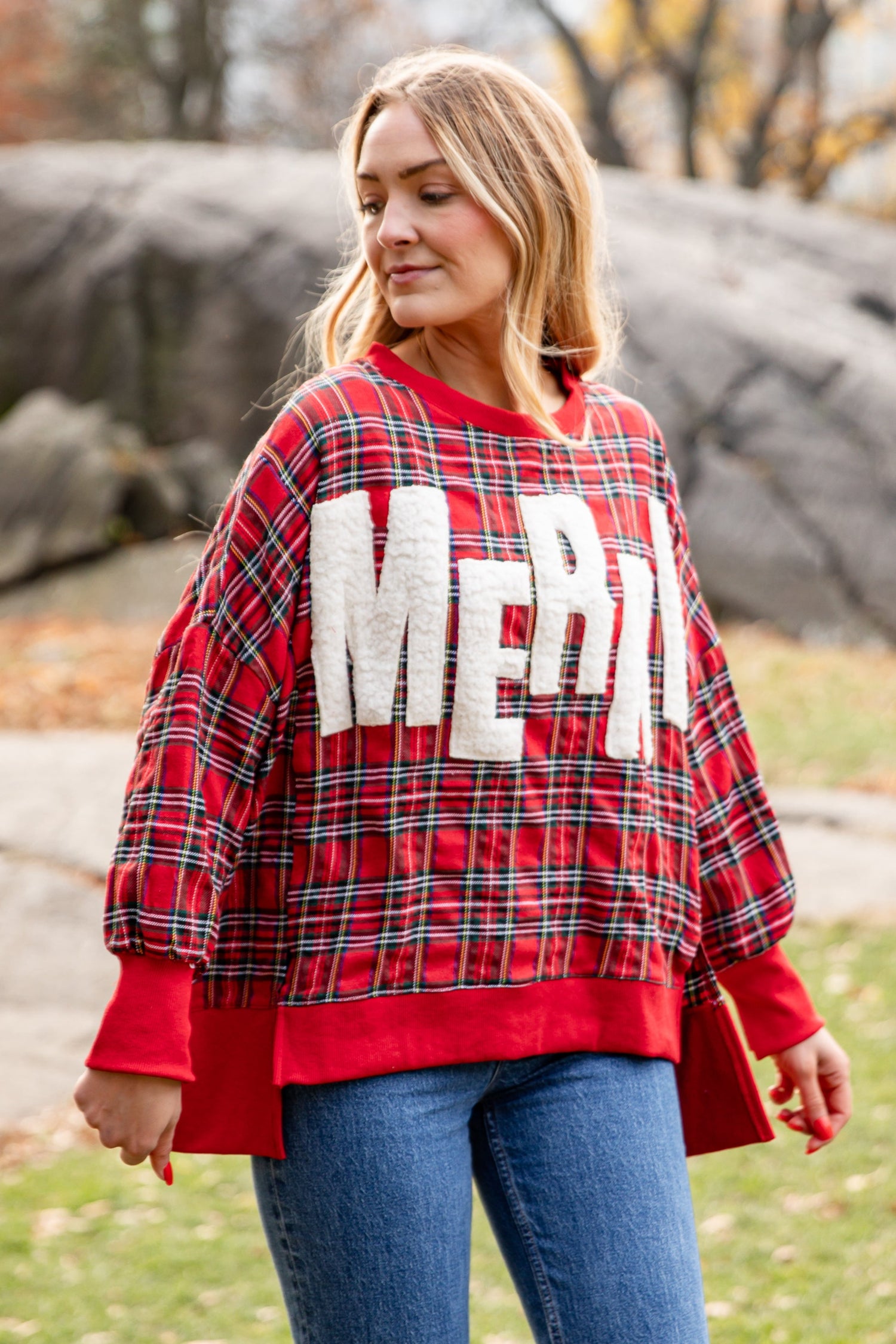 Woman wearing a red plaid sweater with &