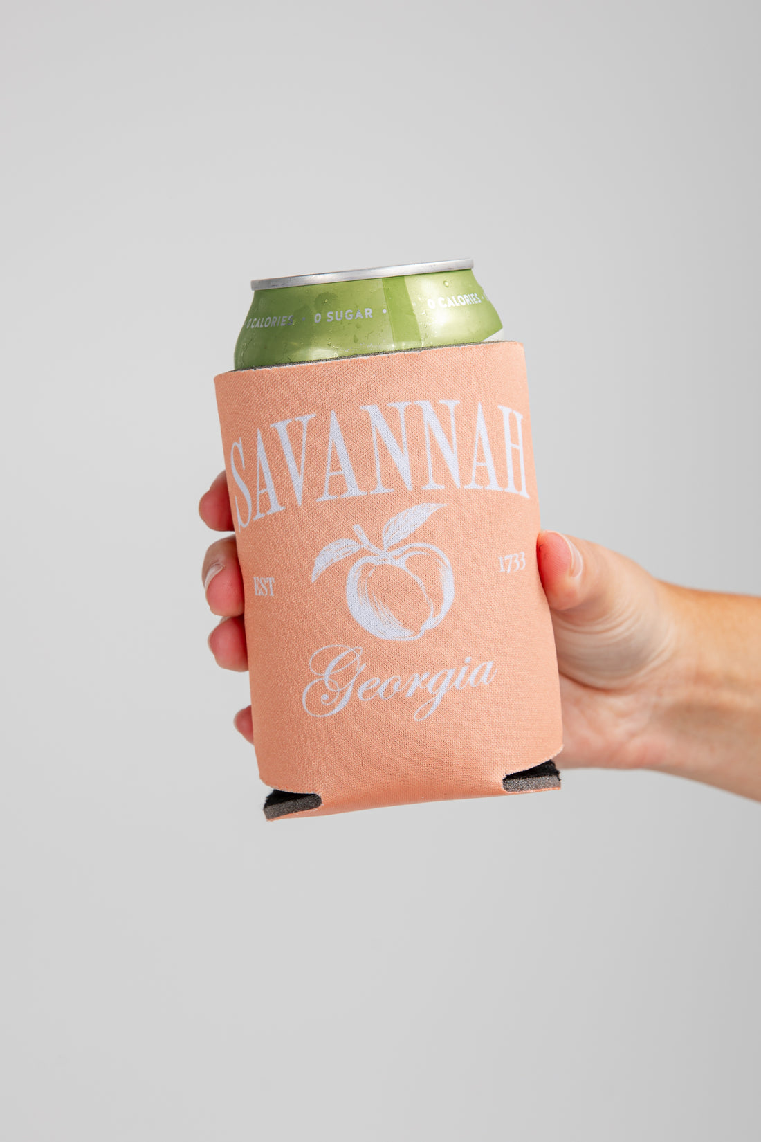 Hand holding a can with a &