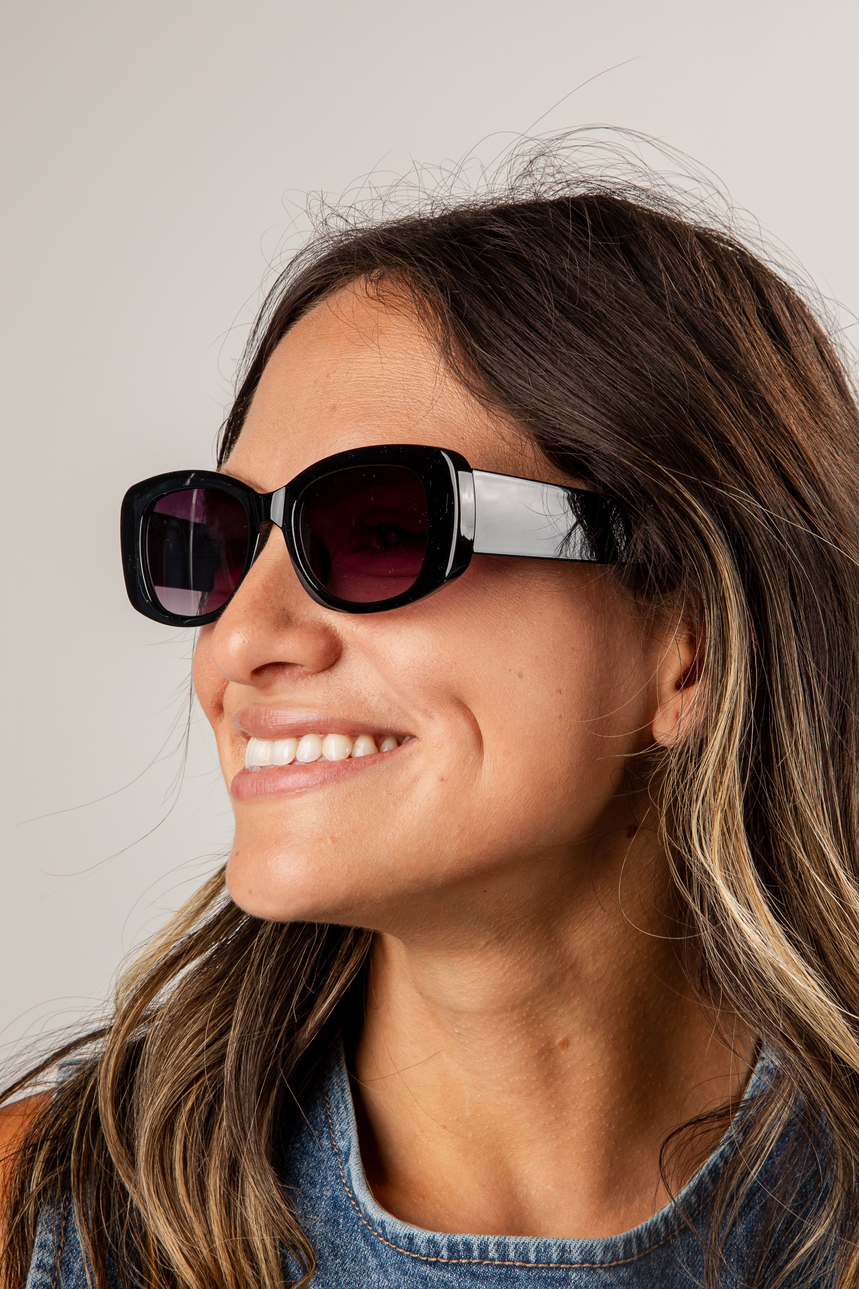 Woman wearing sunglasses with a neutral background