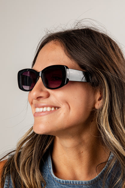 Woman wearing sunglasses with a neutral background