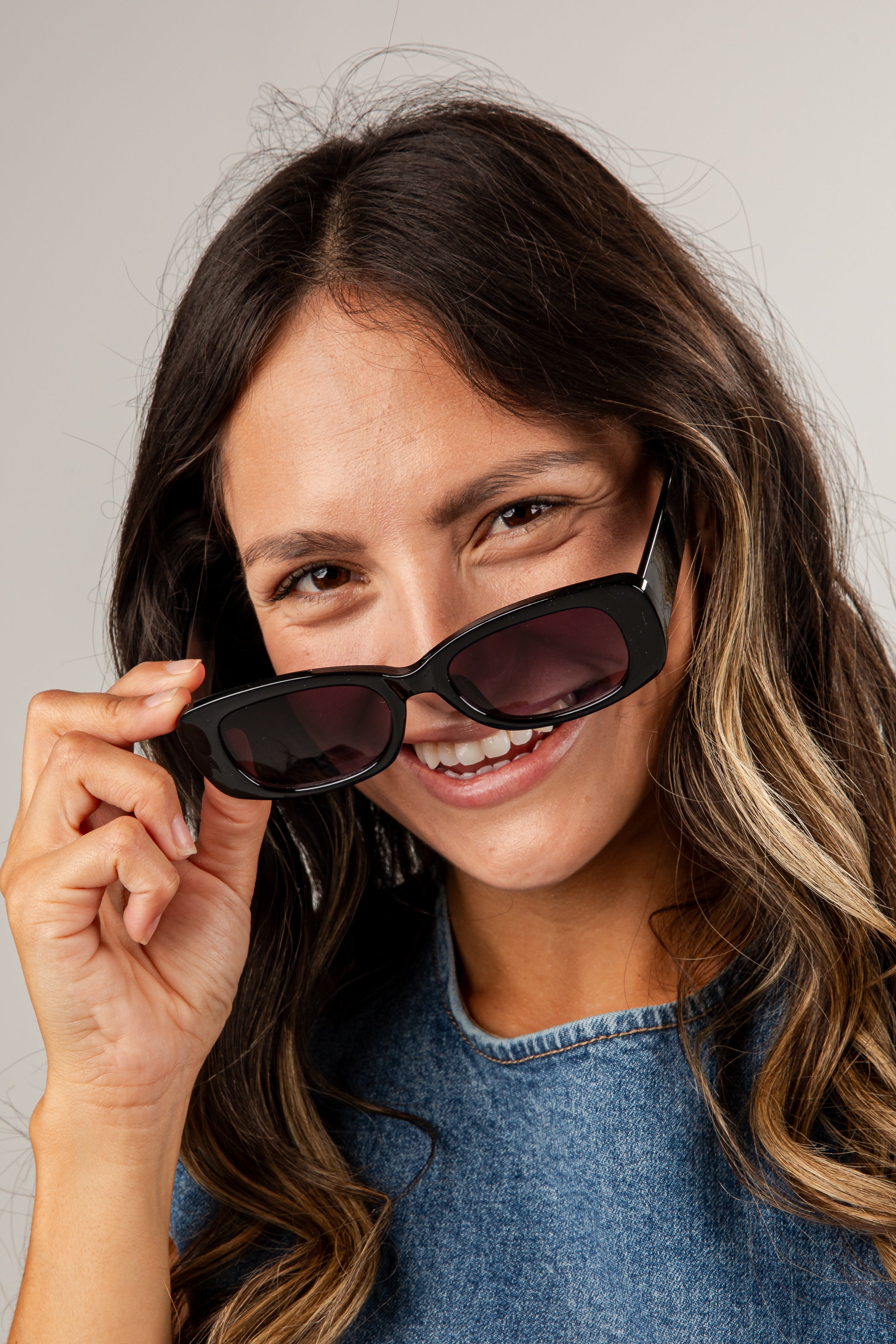 Woman wearing sunglasses with a neutral background