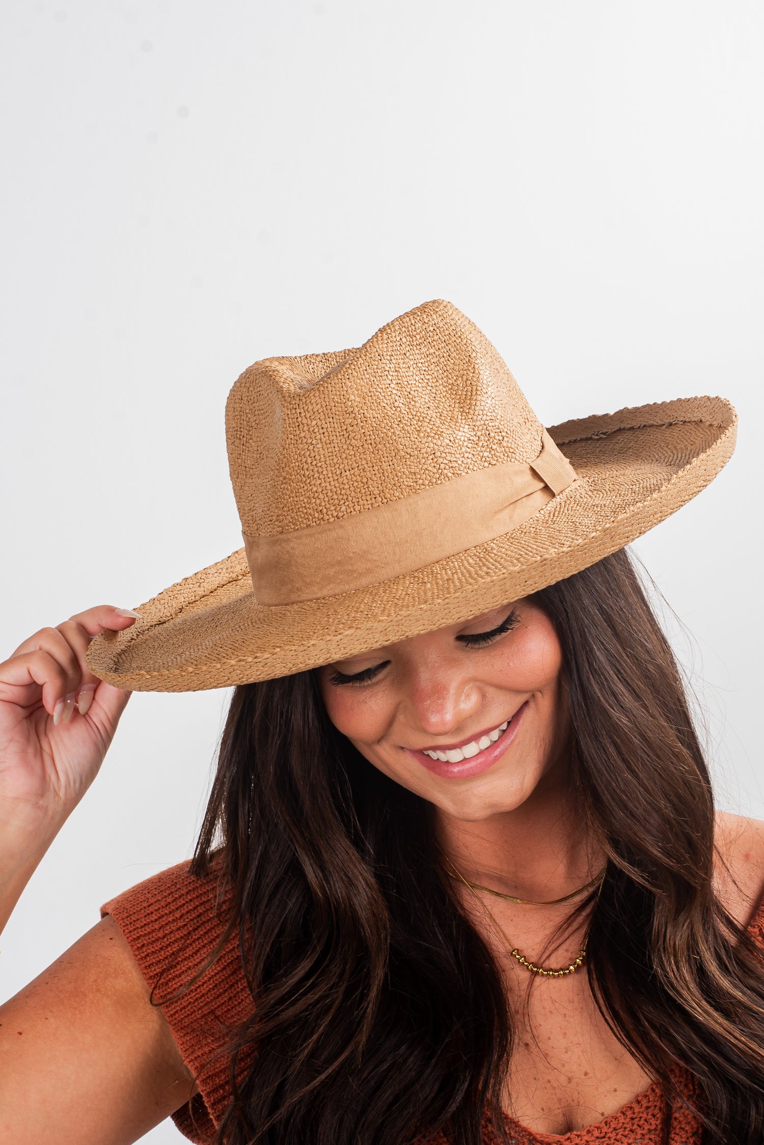 Woman wearing a straw hat against a plain background