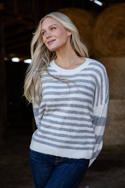 Woman wearing a striped sweater in a barn setting