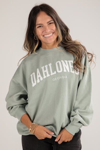 Woman wearing a green sweatshirt with &