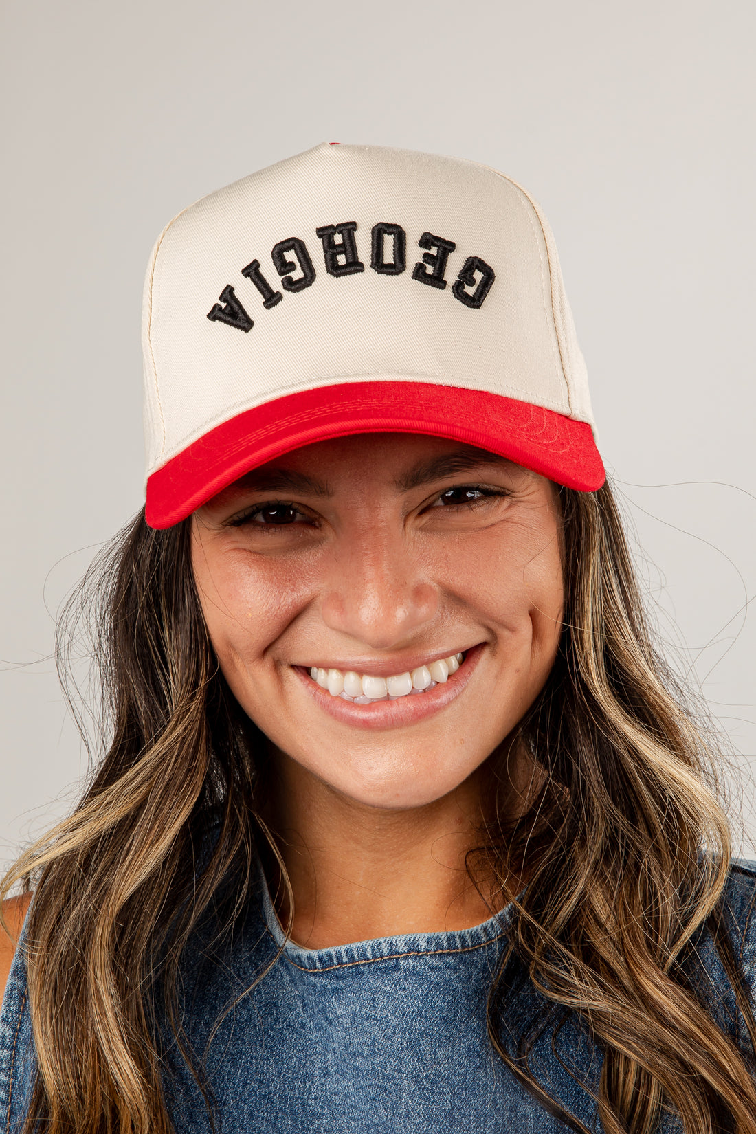 Person wearing a beige and red cap with &