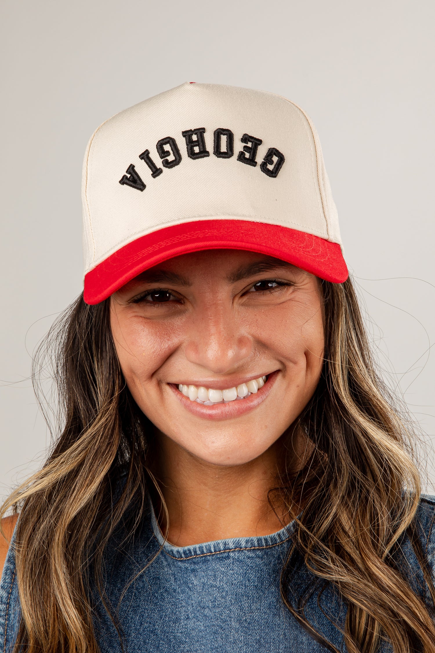 Person wearing a beige and red cap with &