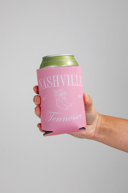 Hand holding a can with a pink sleeve featuring &