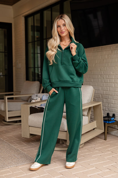 Woman wearing a green tracksuit standing in an outdoor setting.