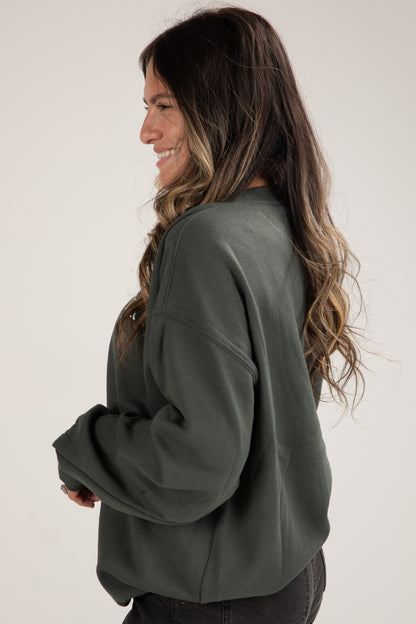 Woman wearing a green sweater against a white background