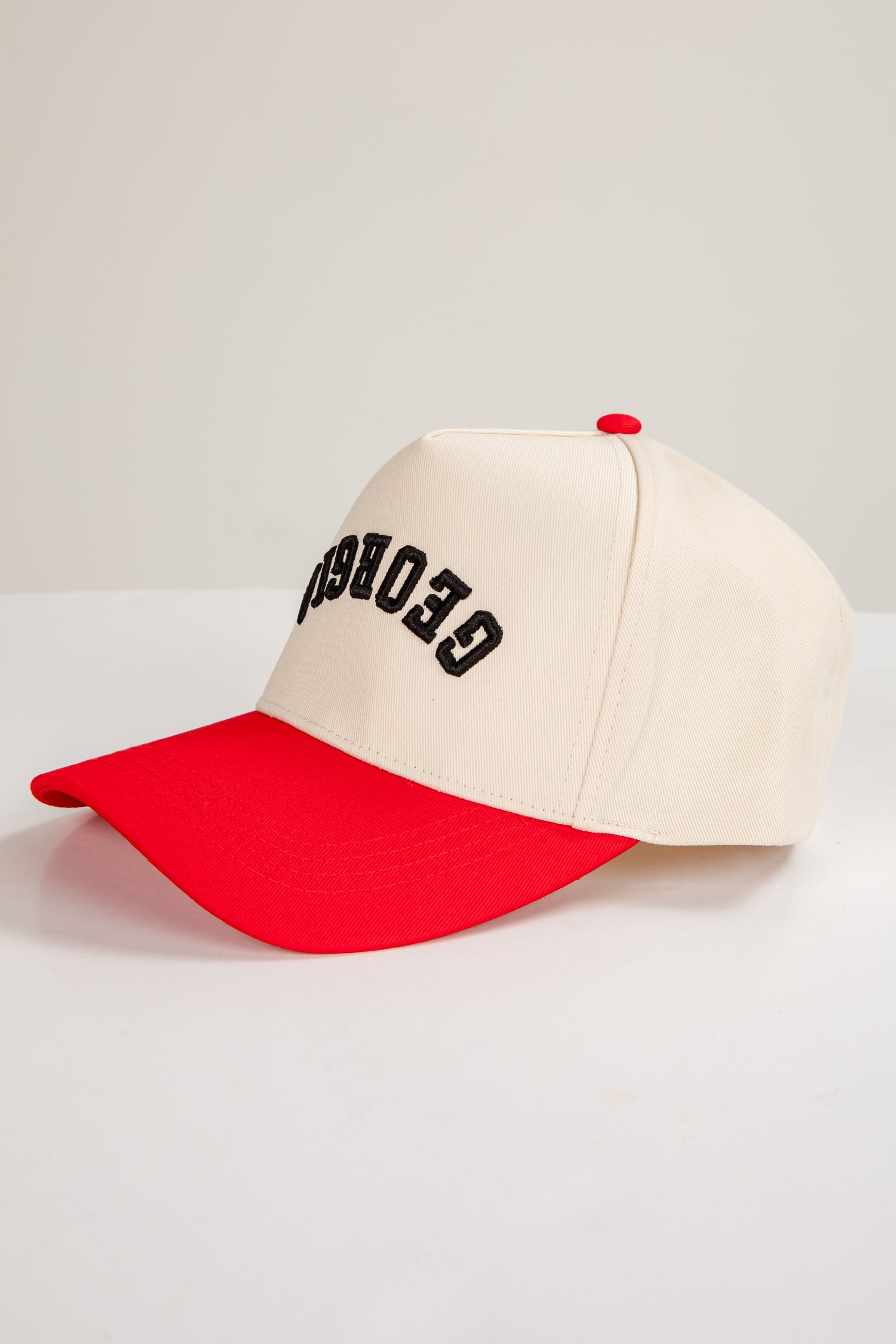 Beige and red cap with black text on a light gray background