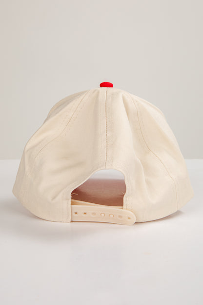 Beige baseball cap with a red button on a light gray background