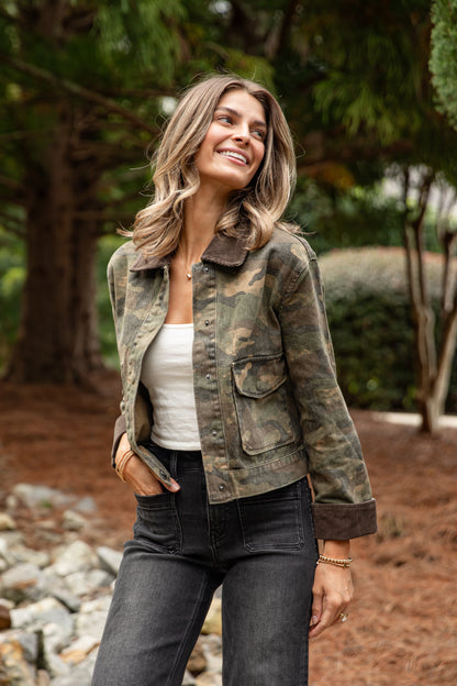 Woman wearing a camouflage jacket in a natural setting