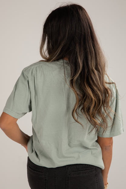 Person wearing a light green t-shirt against a plain background