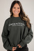 Woman wearing a dark green sweatshirt with &